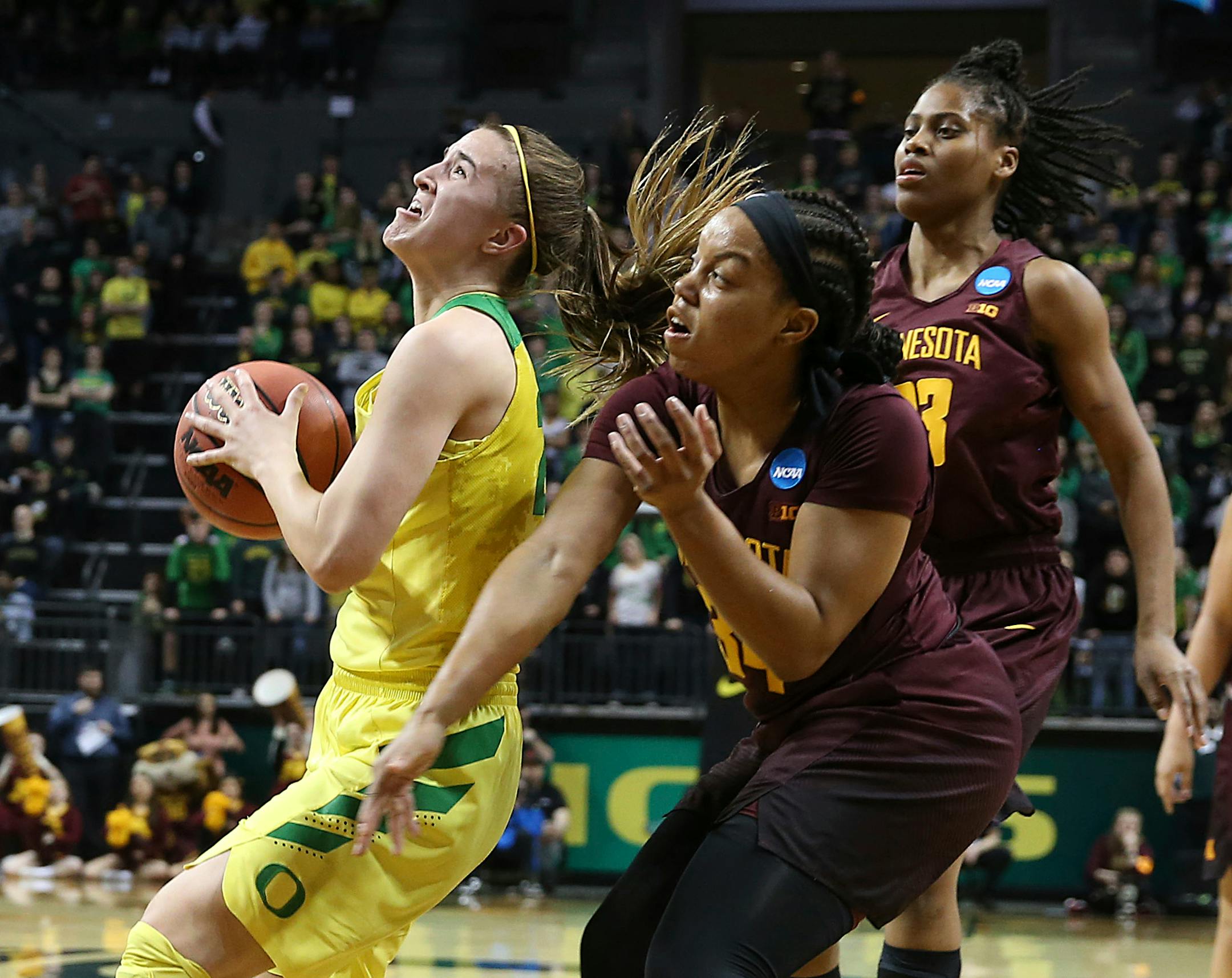 Oregon's Sabrina Ionescu, left, is fouled by Minnesota's Gadiva Hubbard with teammate Kenisha Bell, right, during the second half of their second-round game in the NCAA women's college basketball tournament in 2018.