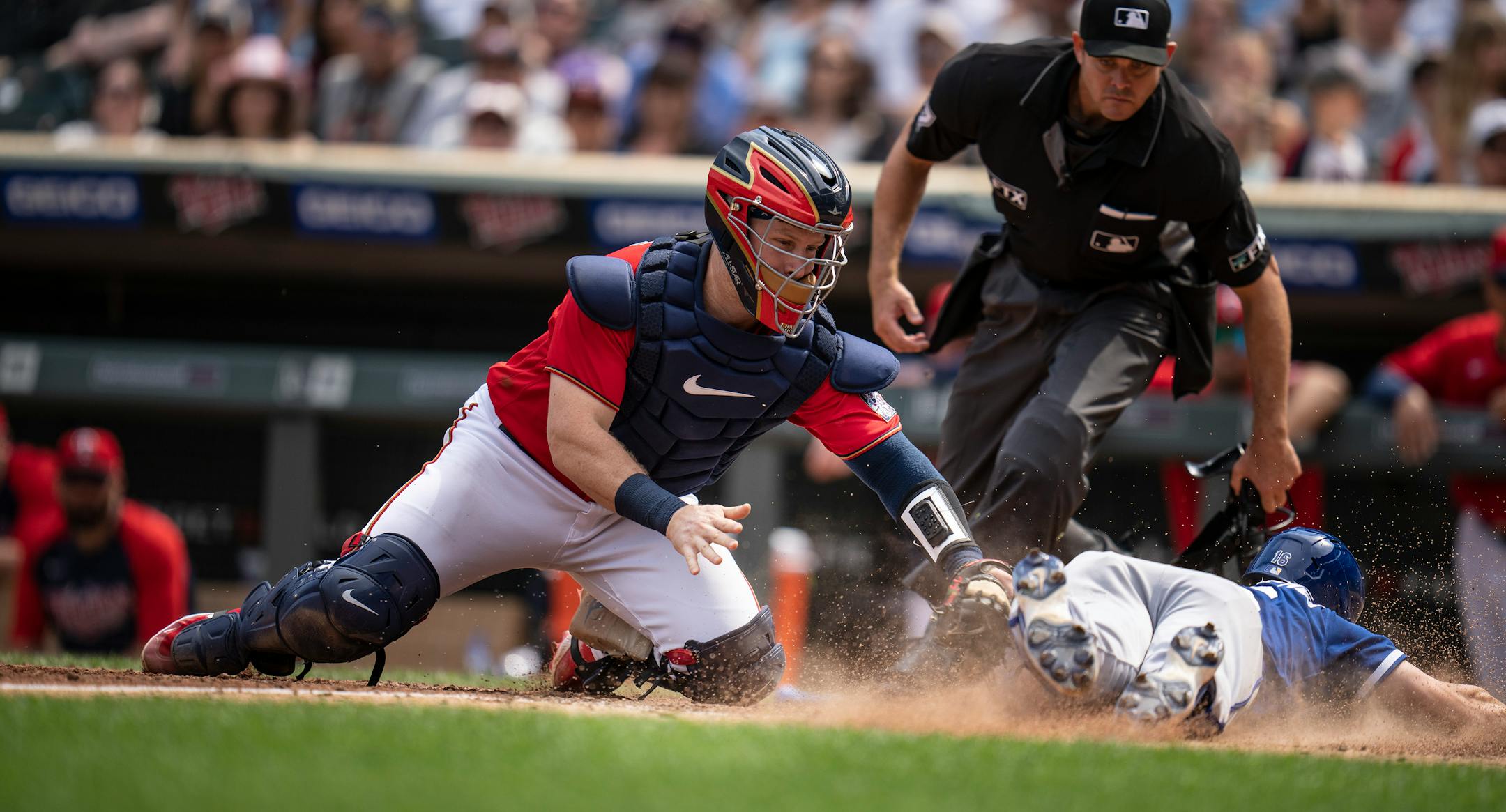 Kansas City Royals left fielder Andrew Benintendi (16) is safe at home in the seventh inning as Minnesota Twins catcher Ryan Jeffers, (27) tried to tag him.