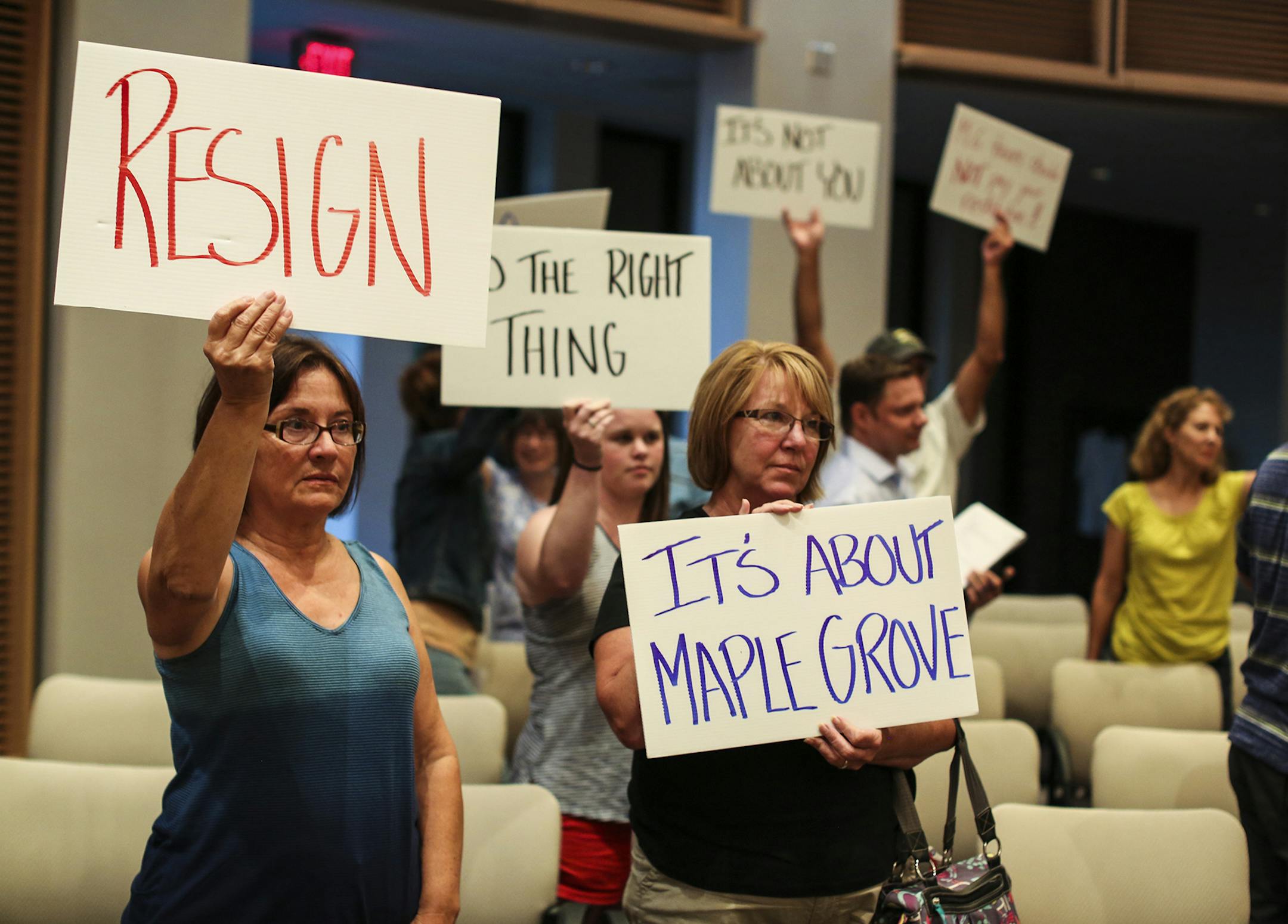 About two dozen protesters, asking for Council Member LeAnn Sargent to resign, including left to right front, Linda Schon and Nancy Whitecotton. held signs at the end of the city council meeting on Monday, August 4, 2014, in Maple Grove, Minn. Around two dozen residents were at Monday's Maple Grove City Council meeting to protest council member LeAnn Sargent's return to the council. Despite being convicted of and serving time for financially exploiting her dying father, Sargent says she's determ