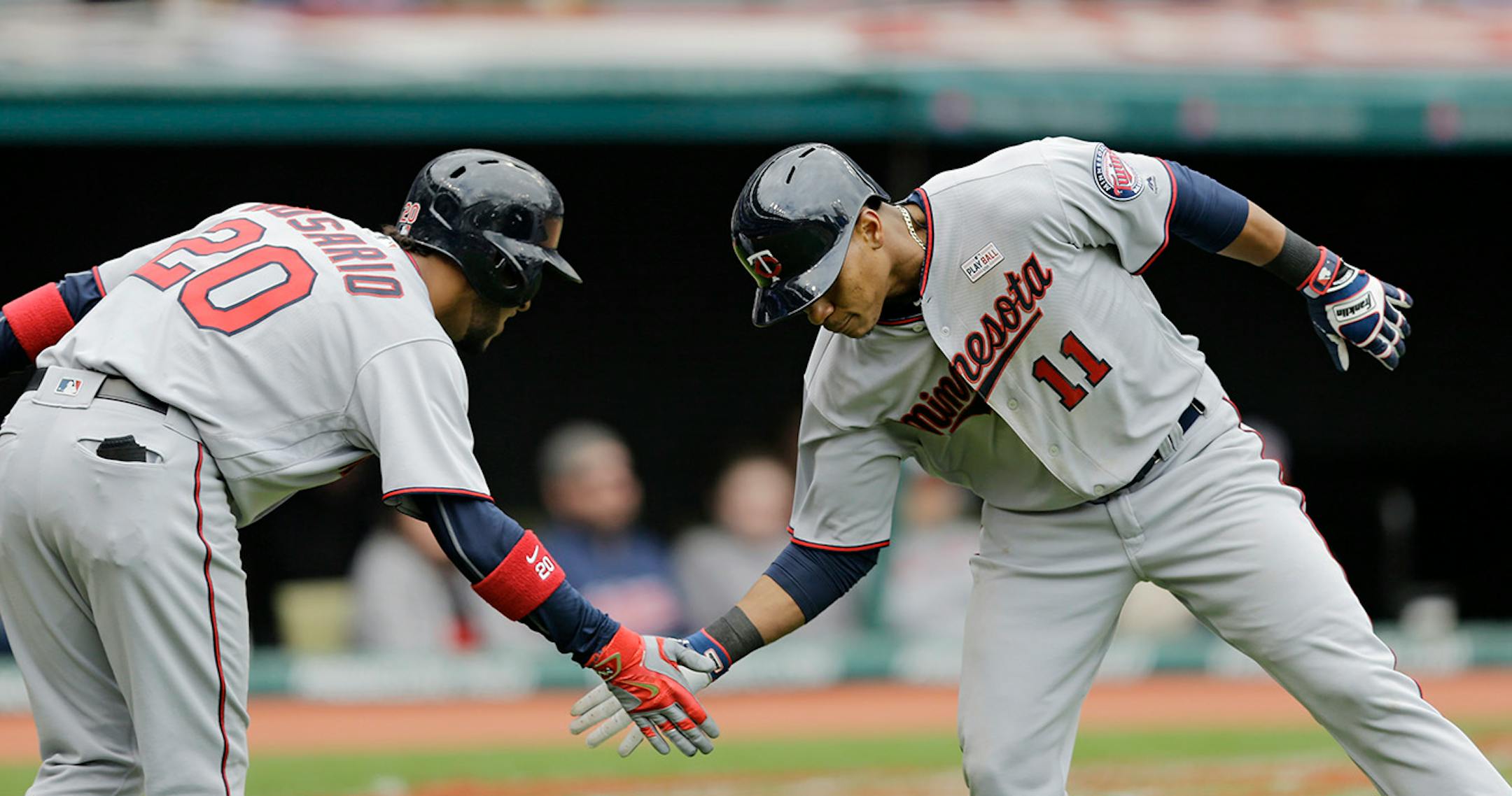 Minnesota Twins' Jorge Polanco, right, is congratulated by Eddie Rosario after Polanco hit a solo home run off Cleveland Indians starting pitcher Trevor Bauer in the sixth inning of a baseball game, Sunday, May 15, 2016, in Cleveland.