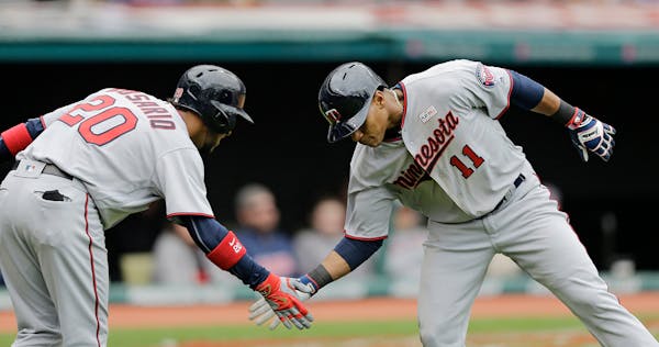 Minnesota Twins' Jorge Polanco, right, is congratulated by Eddie Rosario after Polanco hit a solo home run off Cleveland Indians starting pitcher Trev