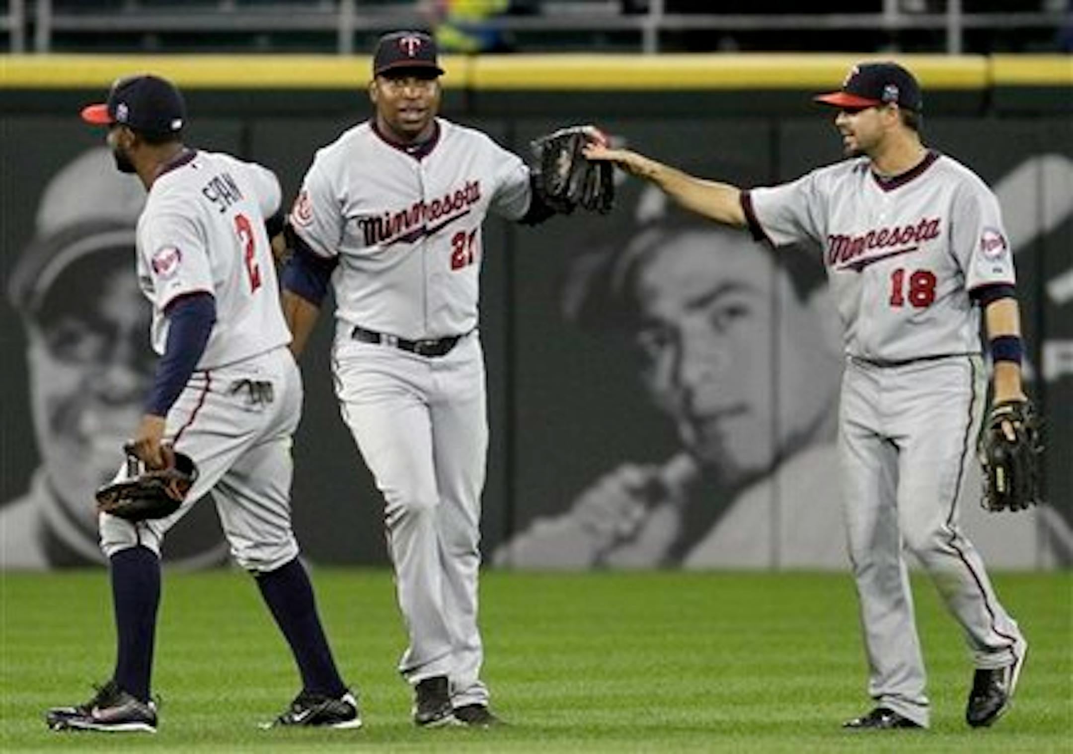 Minnesota Twins' Delmon Young, center, celebrates with Denard Span, left, and Jason Repko after they defeated the Chicago White Sox 8-5 in a baseball game in Chicago, Thursday, Sept. 16, 2010. (AP Photo/Nam Y. Huh)