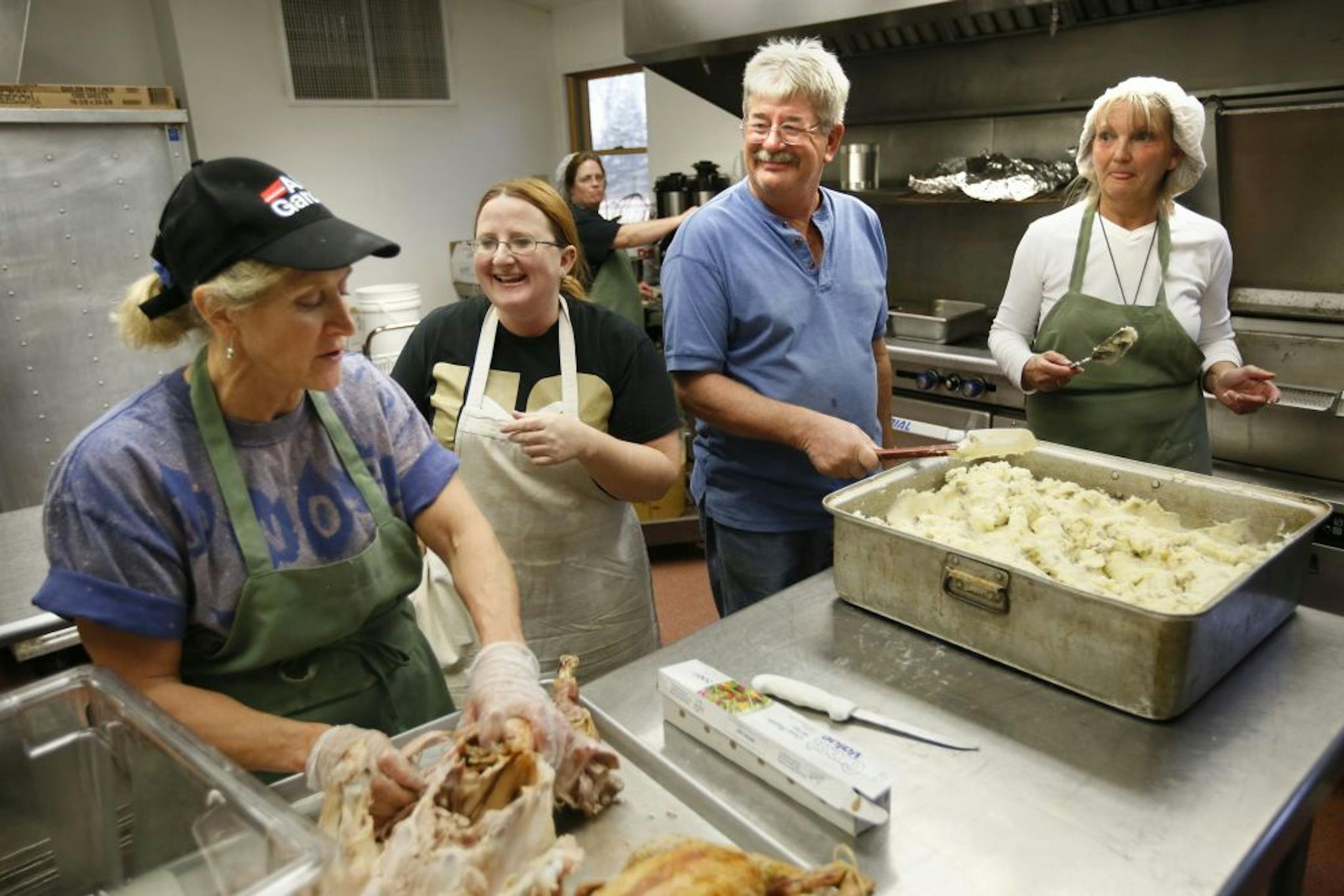 Tracy Turner, in the white apron, and volunteers with Unseen Angels readied Thanksgiving dinner for thousands of people. With Turner at Camp St. Croix near Hudson, Wis., were, from left, Jane Reed, Beth Mondor, Roger Bevers and Jill Burchill.