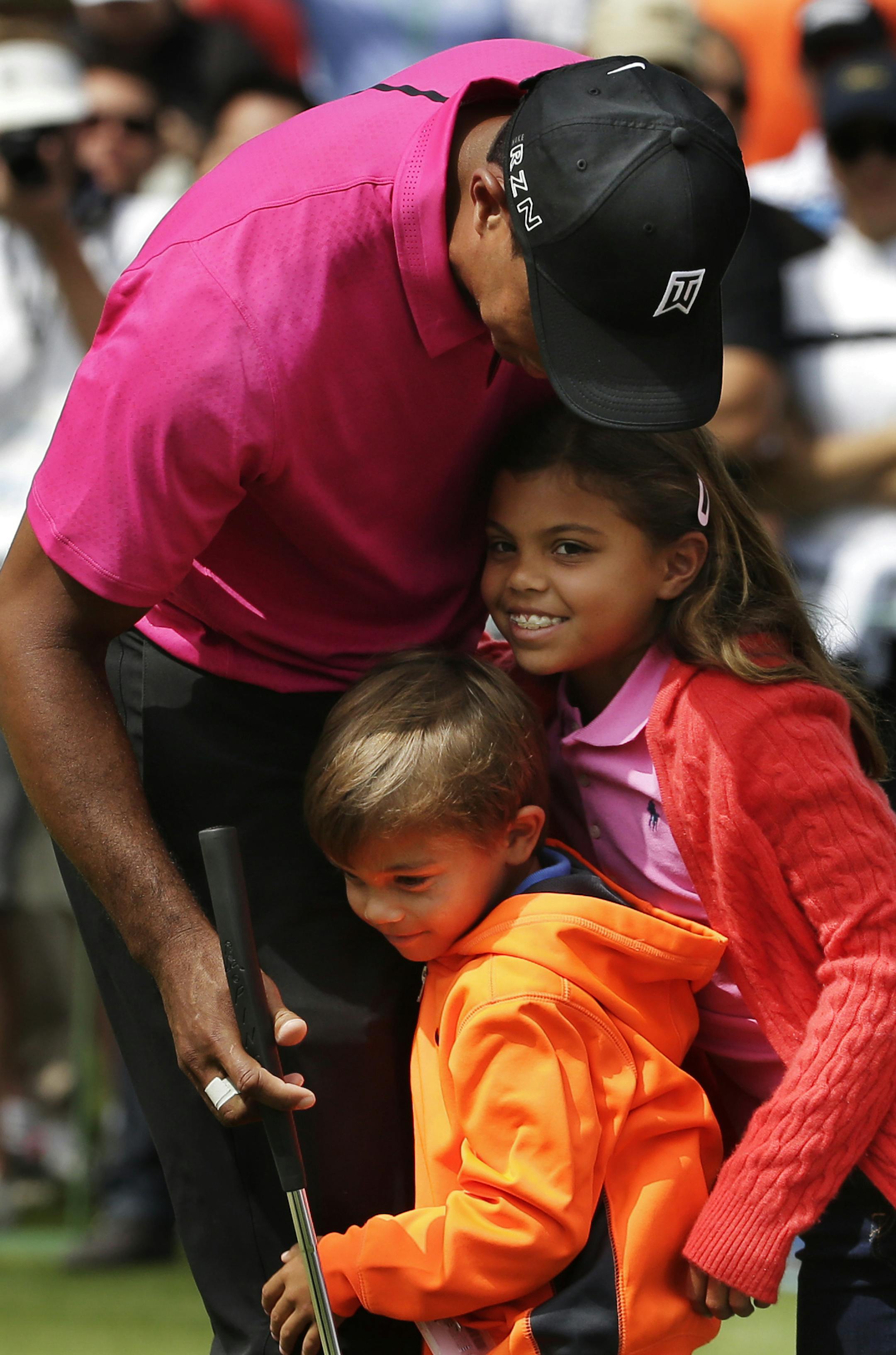 Tiger Woods hugs his children Charlie, left and Sam during a practice round for the Masters golf tournament Tuesday, April 7, 2015, in Augusta, Ga. (AP Photo/Chris Carlson)