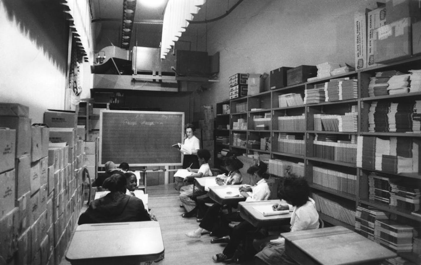 Genevieve Shubitz conducts a sixth-grade spelling class using a portable blackboard. The "classroom" is a storage area behind the auditorium stage at Maxfield School in St. Paul. Maxfield was the only remaining black elementary school in the Twin Cities at the time of this photo, May 28, 1971, by Minneapolis Tribune photographer Powell Krueger. The photo ran in the June 2, 1971, Tribune.