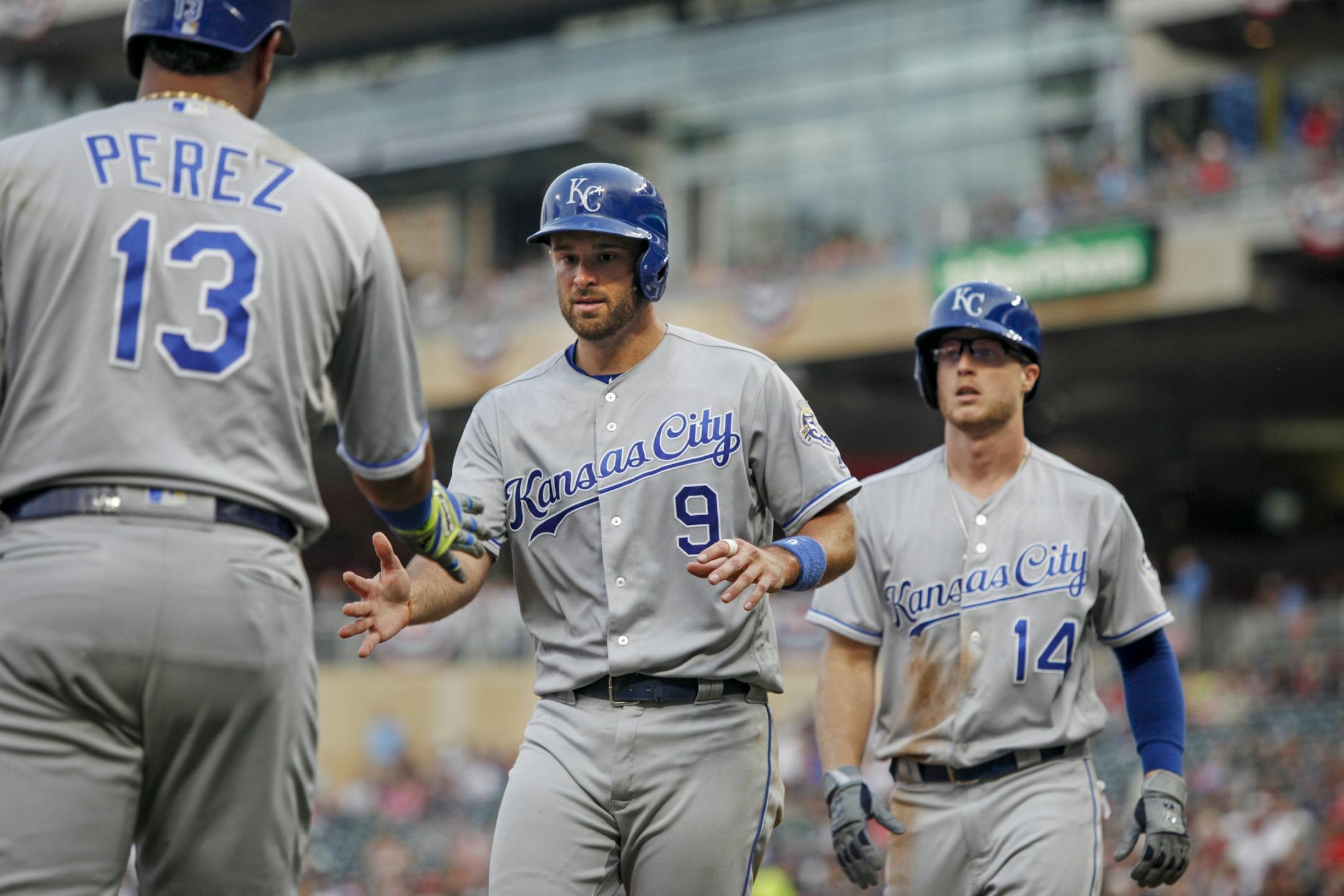 Kansas City Royals' Drew Butera (9) and Brett Phillips (14) celebrate with Salvador Perez (13) after Butera and Phillips scored against the Minnesota Twins during the third inning of a baseball game Saturday, Aug. 4, 2018, in Minneapolis.