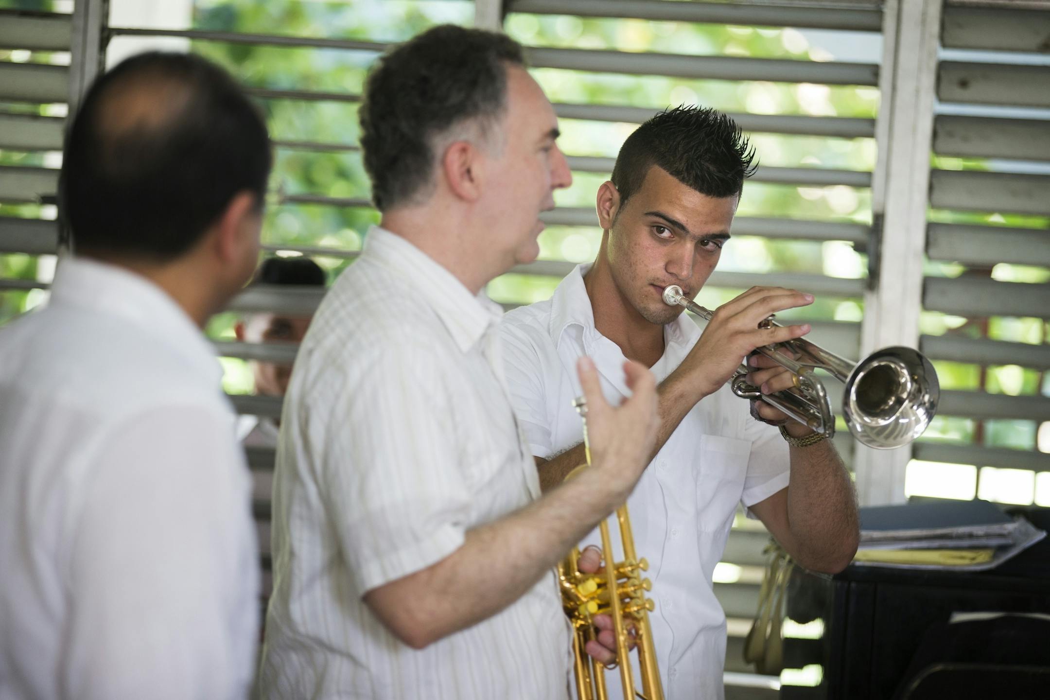 Antonio Diaz Martinez, right, a trumpet player and student at the Escuela Nacional de Musica, listens to instructions from Minnesota Orchestra trumpet players Manny Laureano, from left, and Robert Dorer during a school visit by the orchestra in Havana, Cuba on Thursday, May 14, 2015.