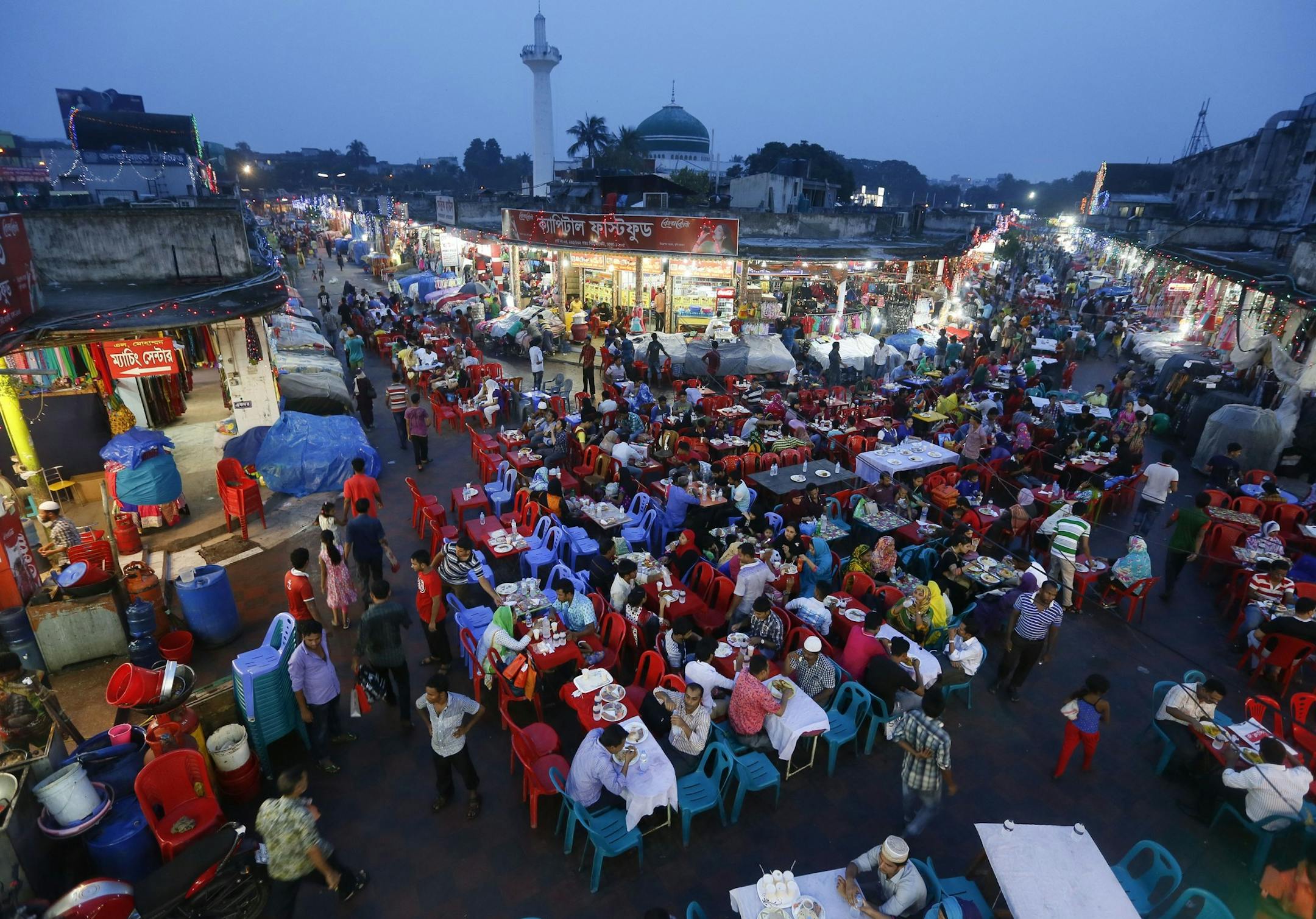 Bangladeshi Muslim devotees break their day long fast at a market during the holy month of Ramadan in Dhaka, Bangladesh, Tuesday, July 14, 2015. Muslims throughout the world are celebrating the holy fasting month of Ramadan, refraining from eating, drinking, and smoking from dawn to dusk. (AP Photo/ A.M. Ahad)