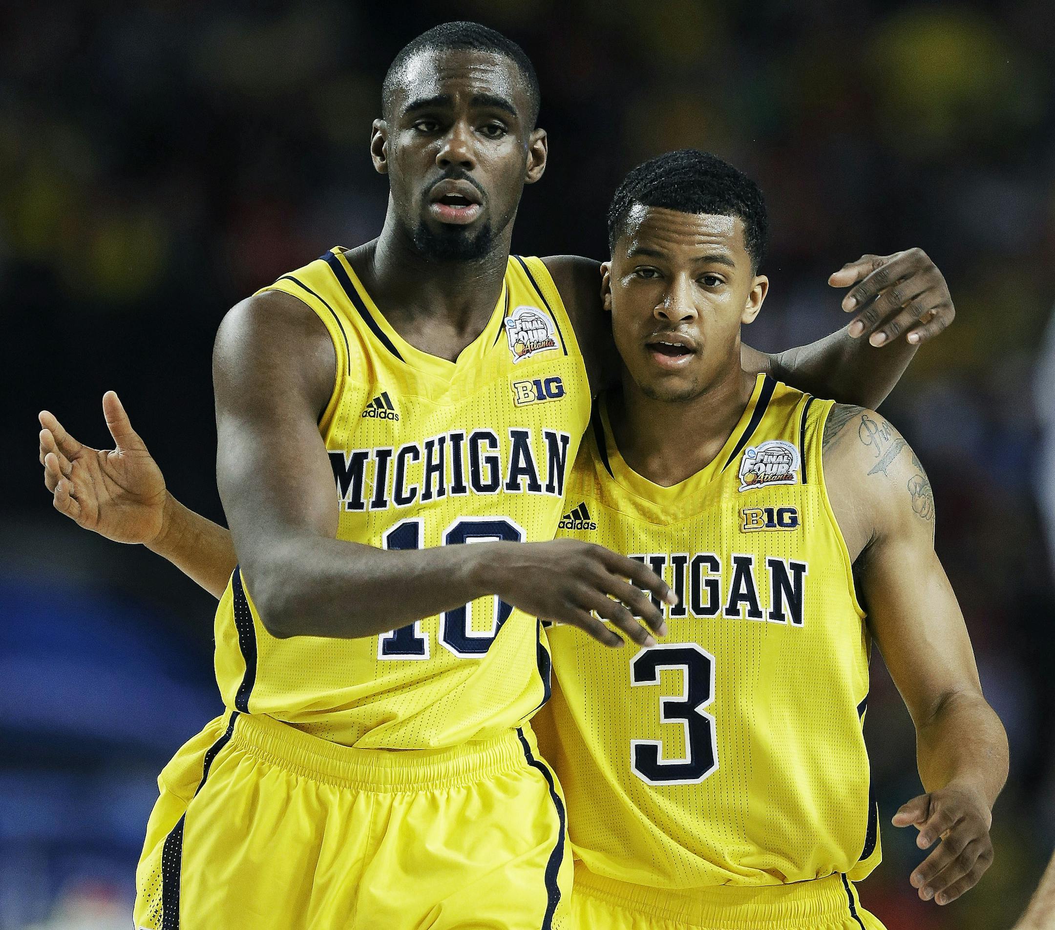 Michigan's Trey Burke, right, and teammate Tim Hardaway Jr. walk down the court during the second half of their NCAA Final Four semifinal game against Syracuse