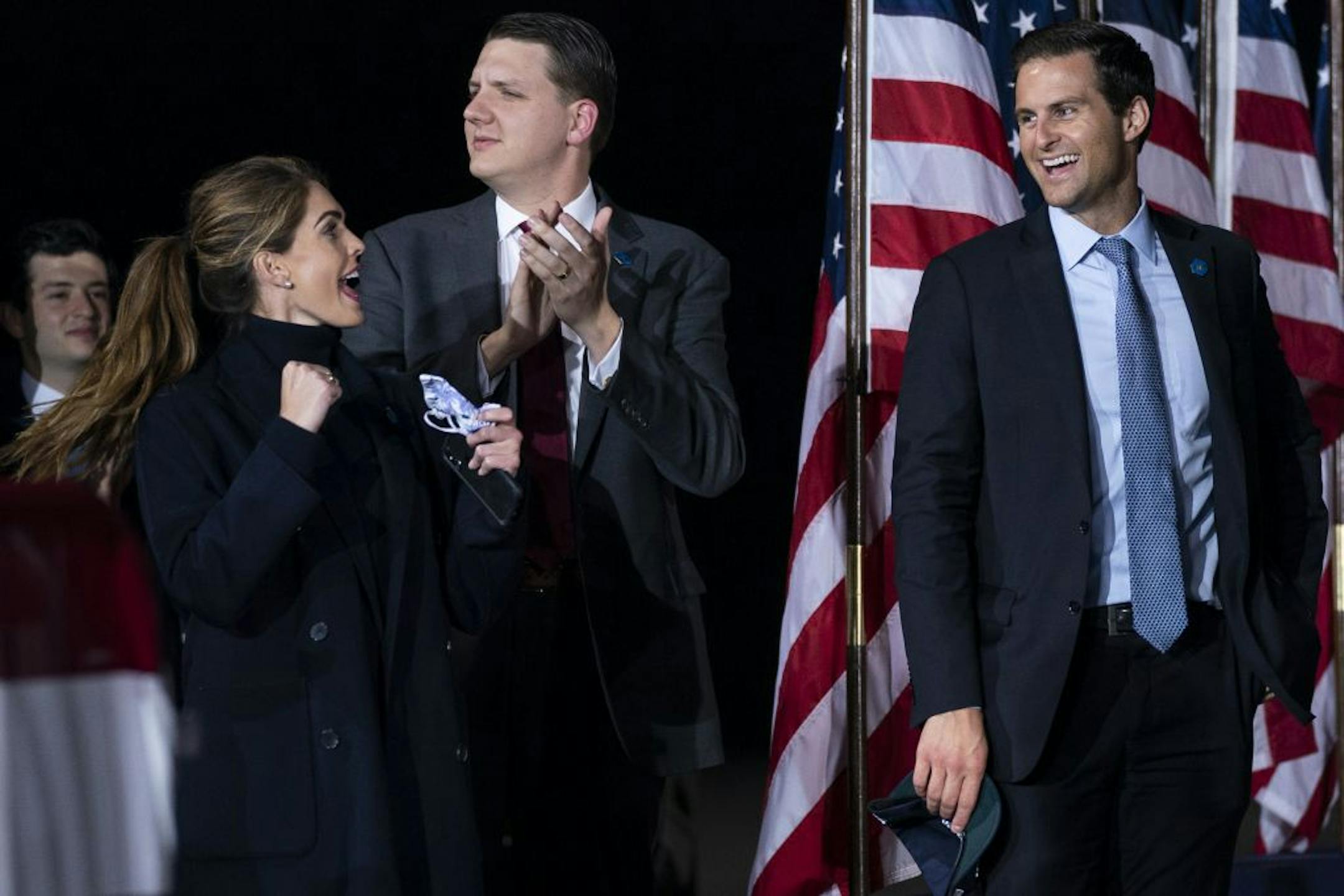 Counselor to the President Hope Hicks cheers as President Donald Trump speaks during a campaign rally at Harrisburg International Airport, Saturday, Sept. 26, 2020, in Middletown, Pa. Special assistant to the President and White House trip director William Russell, center, and director of the White House personnel office John McEntee, watch.
