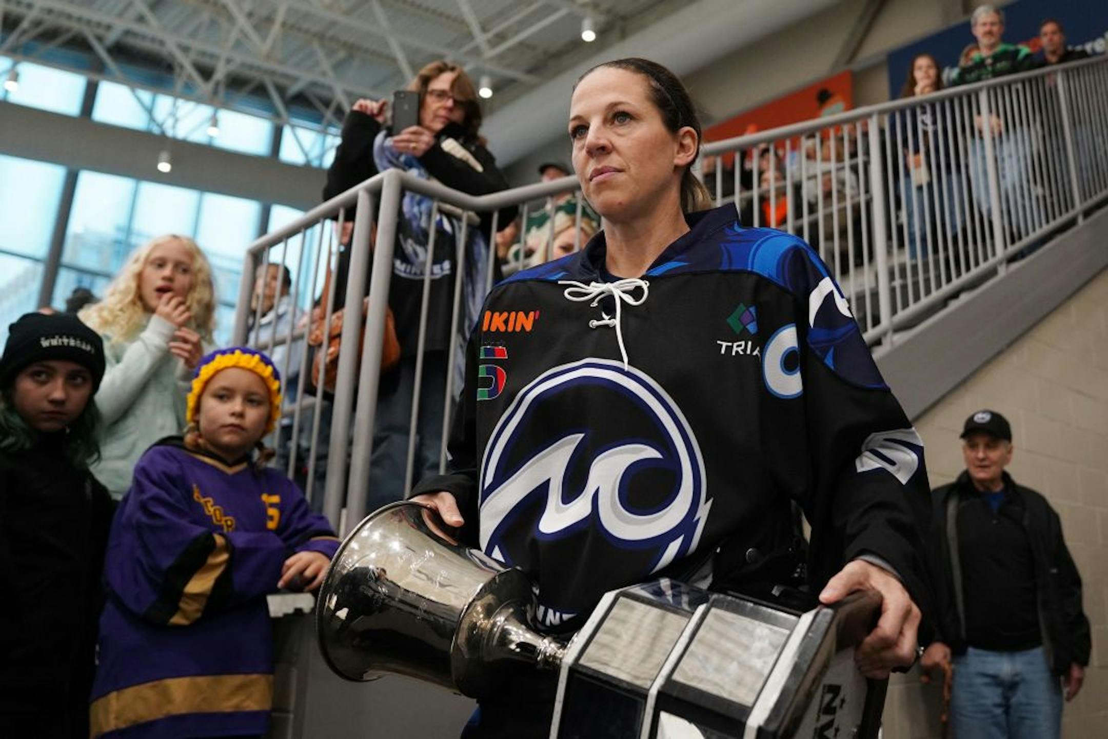 Whitecaps defenseman Winny Brodt Brown (5) carried out the team's the Isobel Cup from winning the NWHL Championship last season ahead of Saturday's game.
