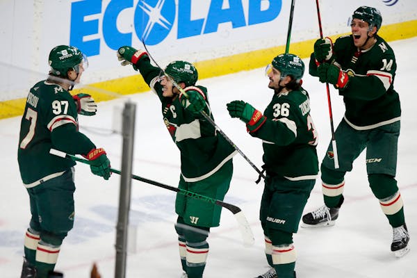 Minnesota Wild left wing Kirill Kaprizov (97) is congratulated after scoring the tying goal by teammates Jared Spurgeon (46) Mats Zuccarello (36) and 