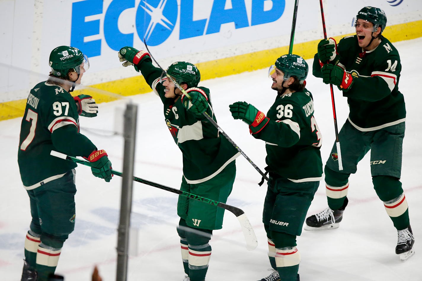 Minnesota Wild left wing Kirill Kaprizov (97) is congratulated after scoring the tying goal by teammates Jared Spurgeon (46) Mats Zuccarello (36) and Joel Eriksson Ek (14) in the third period of an NHL hockey game against the Columbus Blue Jackets, Saturday, March 26, 2022, in St. Paul, Minn. (AP Photo/Andy Clayton-King)