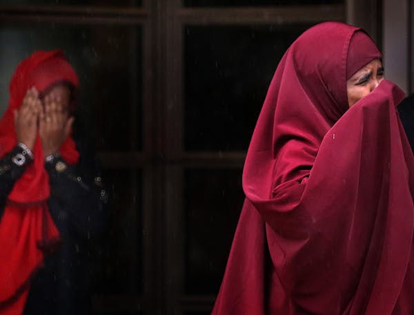 Farhiyo Mohamed, right, the mother of defendant Abdirahman Daud, and a second woman emerge in tears from the federal courthouse in Minneapolis on Frid