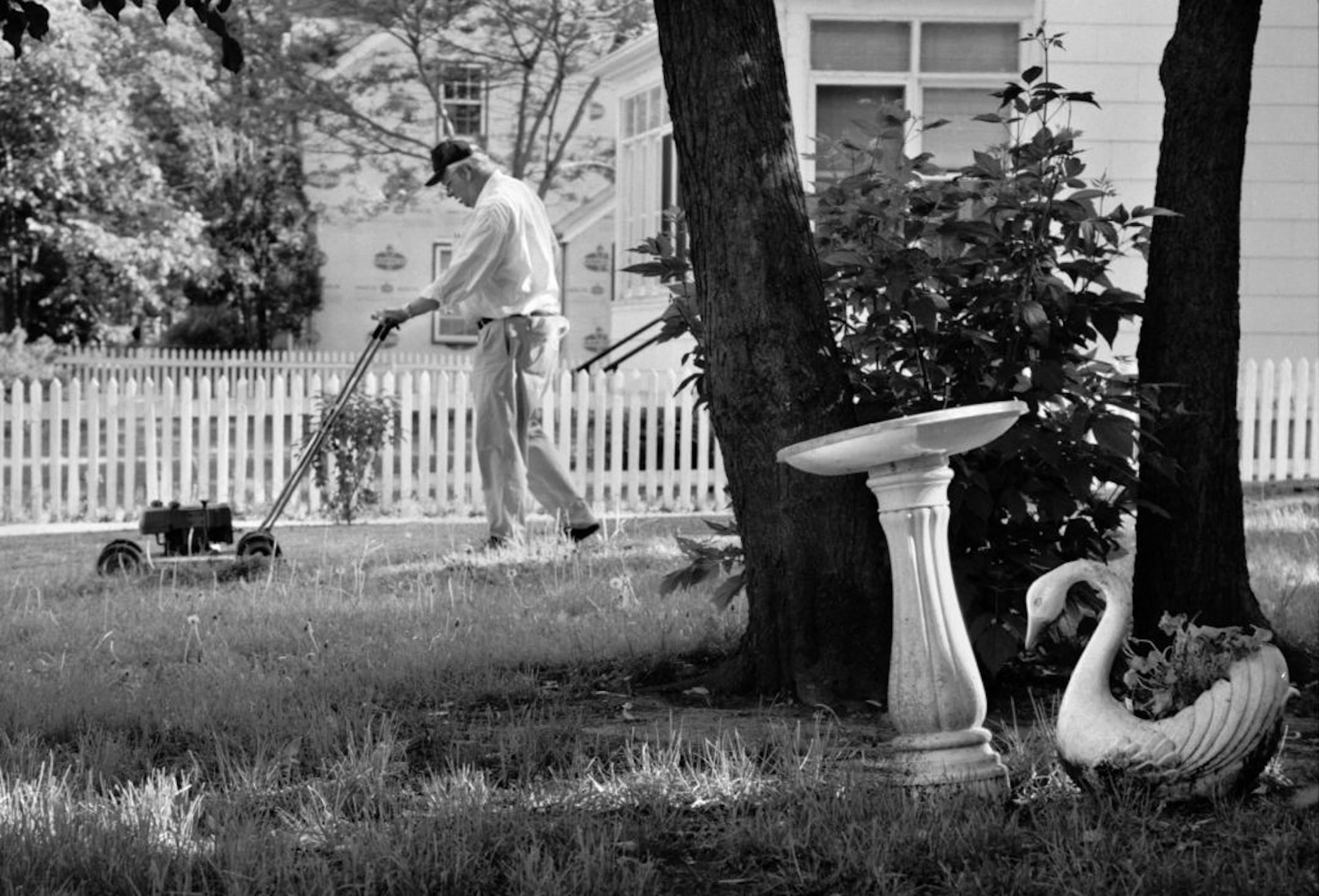 1996: One of two block captains, George Bazoff mows the grass in a vacant lot next to his home on Colfax Avenue N. He also mows the lawn of the a duplex next door to his house to fulfill a promise he made to the landlord that he mow in exchange for good neighbors.