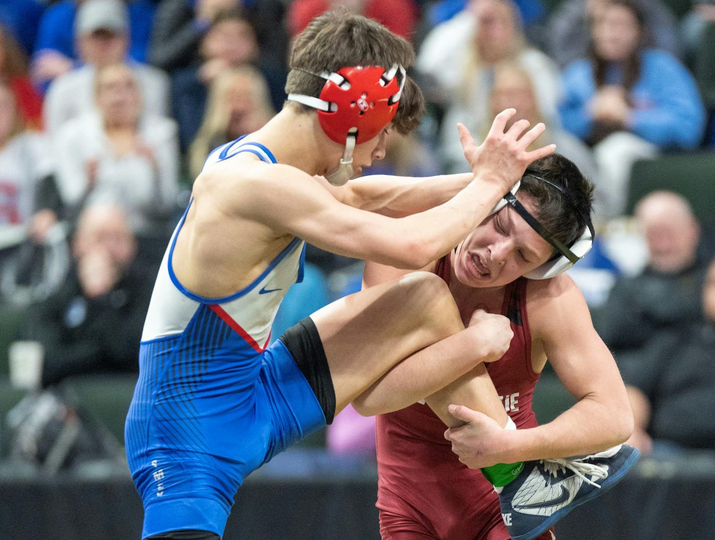 New Prague wrestler Lawson Eller grabs the leg of Simley wrestler Austin Grzywinski during the MSHSL wrestling state tournament championships Saturday, March 4, 2023 at Xcel Energy Arena in St. Paul, Minn. ]