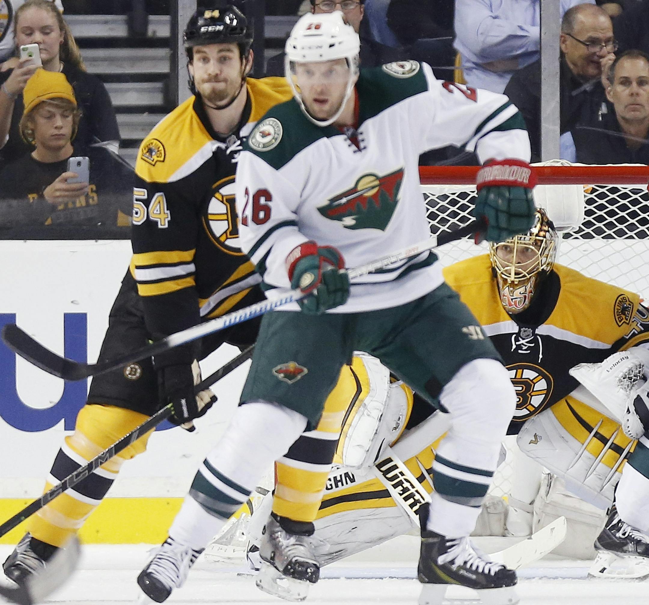 Boston Bruins' Tuukka Rask, of Finland, behind tends goal as teammate Adam McQuaid (54) defends against Minnesota Wild's Thomas Vanek (26) and Nino Niederreiter (22), of Switzerland, in the second period of an NHL hockey game in Boston, Tuesday, Oct. 28, 2014. (AP Photo/Michael Dwyer)
