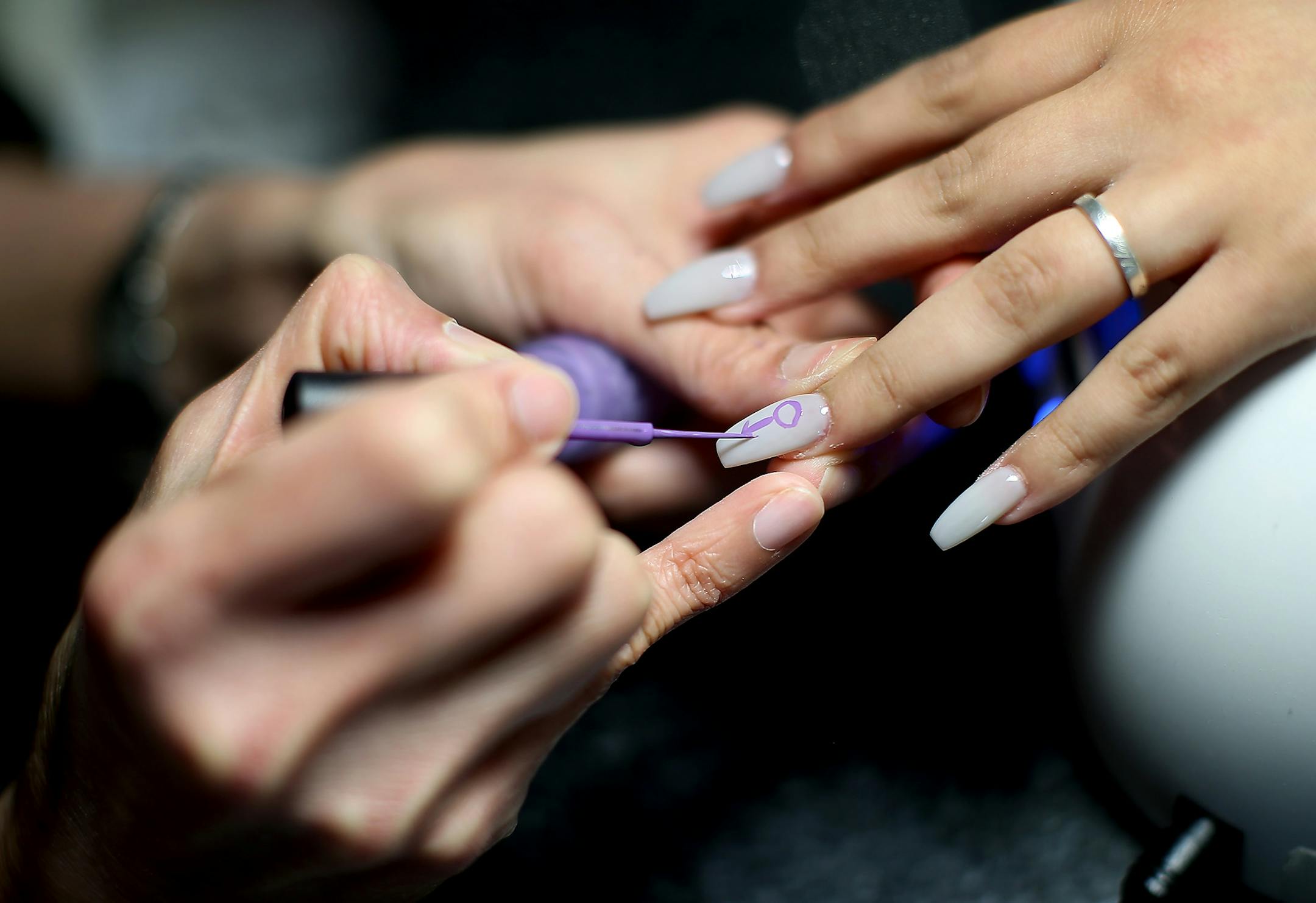 Lauren Salgado watched as nail technician Julie Nghi, cq, worked on her nails at USA Nails, Friday, April 22, 2016 in St. Louis Park, MN. Salgado was there to get the Prince sign painted on her nails in honor of him.