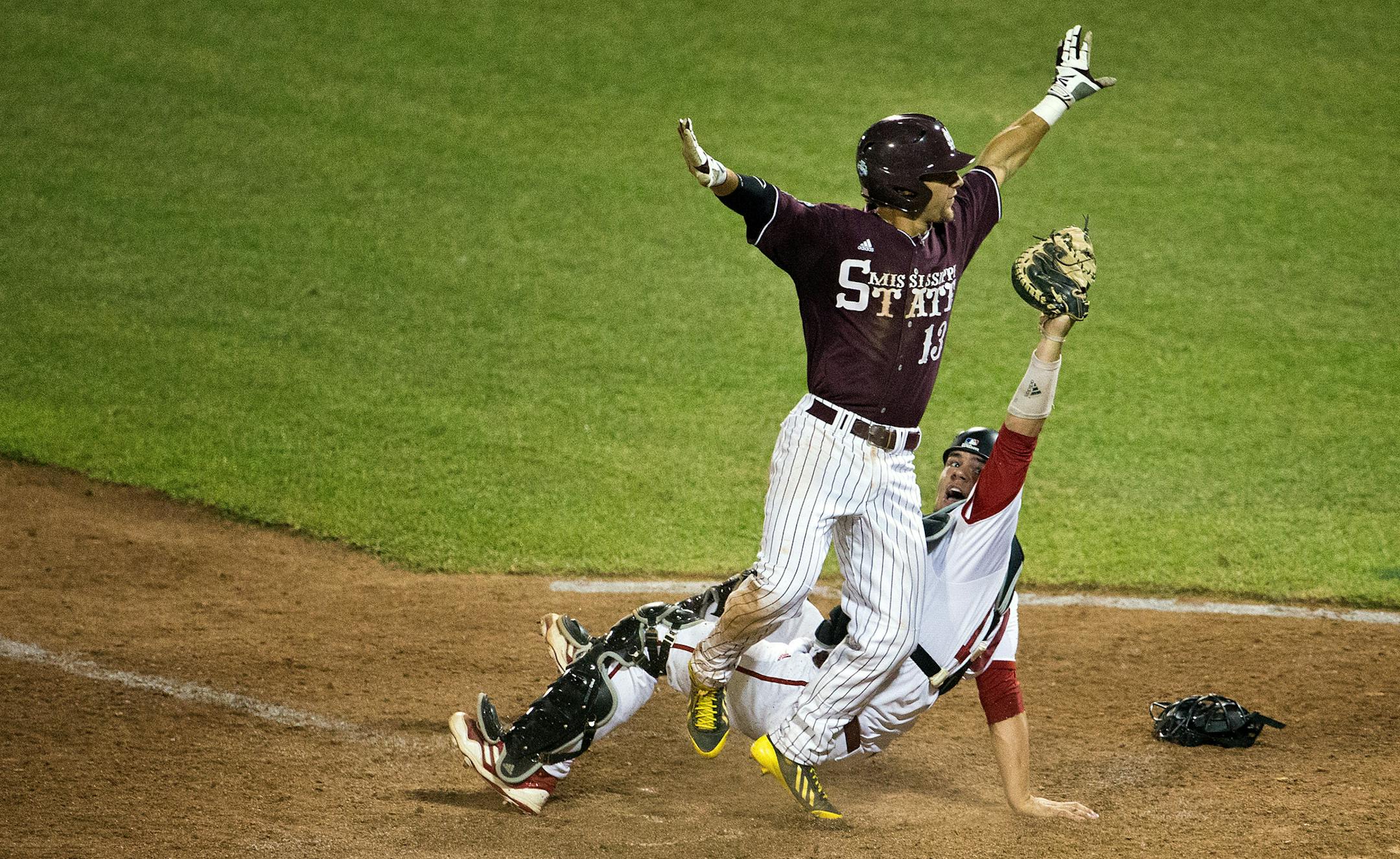 Mississippi State's Brett Pirtle (13) collides with Indiana catcher Kyle Schwarber (10) at home plate to tie the score 3-3 in the top of the eighth inning in game six of the College World Series at TD Ameritrade Park in Omaha, Neb., Monday, June 17, 2013. (AP Photo/The Omaha World-Herald/Mark Davis)† MAGS OUT TV OUT