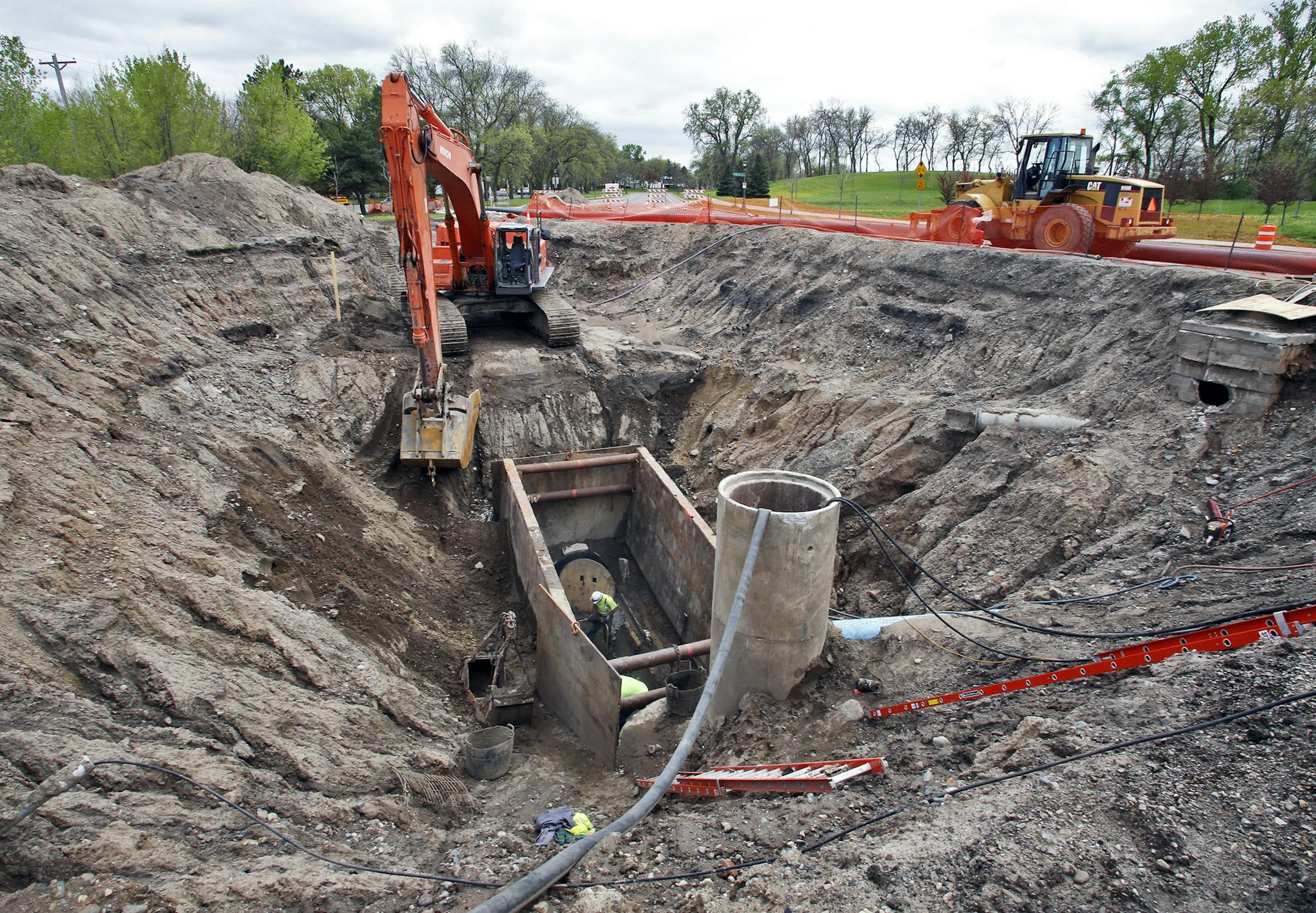 Municipal workers repair the sewer line at the bottom of the sinkhole. ] A regional sewer line ruptured recently near Phalen Park on Johnson Parkway in St. Paul causing the opening of a large sinkhole. (MARLIN LEVISON/STARTRIBUNE(mlevison@startribune.com)