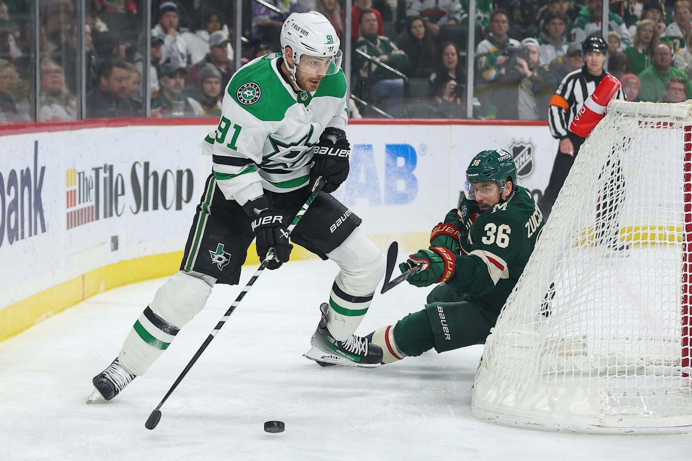 Dallas Stars center Tyler Seguin, left, skates with the puck as Minnesota Wild right wing Mats Zuccarello (36) defends during the first period of an NHL hockey game Monday, Jan. 8, 2024, in St. Paul, Minn. (AP Photo/Matt Krohn)