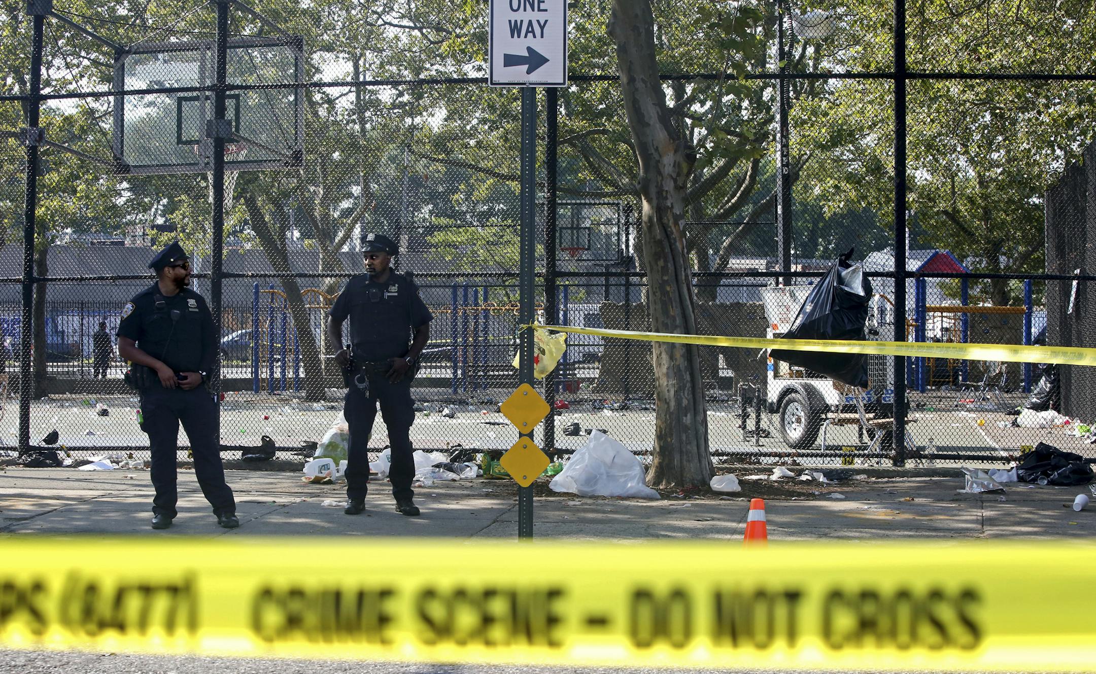Police officers at the scene of a shooting near the Brownsville Recreation Center in Brooklyn, July 28, 2019. Thousands were gathered near a playground for the annual Old Timers Day in Brownsville when two gunmen began firing, killing one man and injuring 11 others, the police said. (Yana Paskova/The New York Times)
