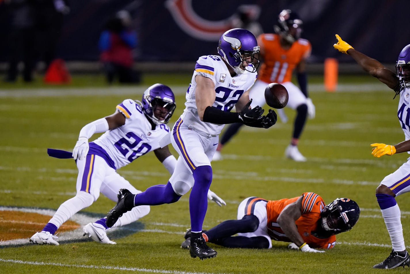 Vikings safety Harrison Smith intercepts a pass with teammates Jeff Gladney (20) and Anthony Harris (41) nearby.