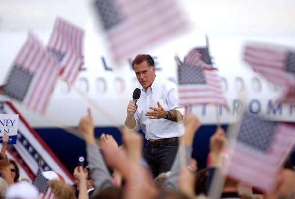 Flags wave as Republican presidential candidate, former Massachusetts Gov. Mitt Romney speaks at Pueblo Weisbrod Aircraft Museum in Pueblo, Colo., Mon