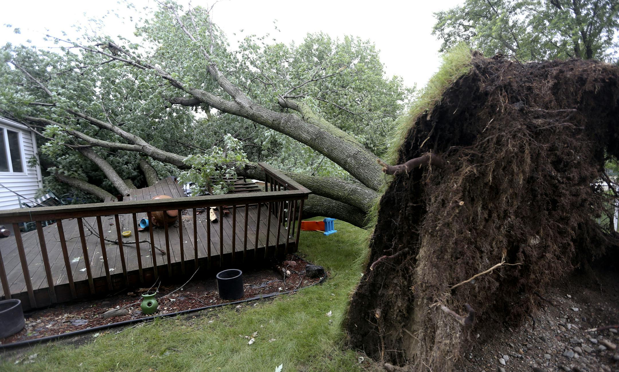 Two trees ripped up the deck and crushed a garage at the Rubio house in St. Louis Park Min., Wednesday, August 7, 2013. ] (KYNDELL HARKNESS/STAR TRIBUNE) kyndell.harkness@startribune.com