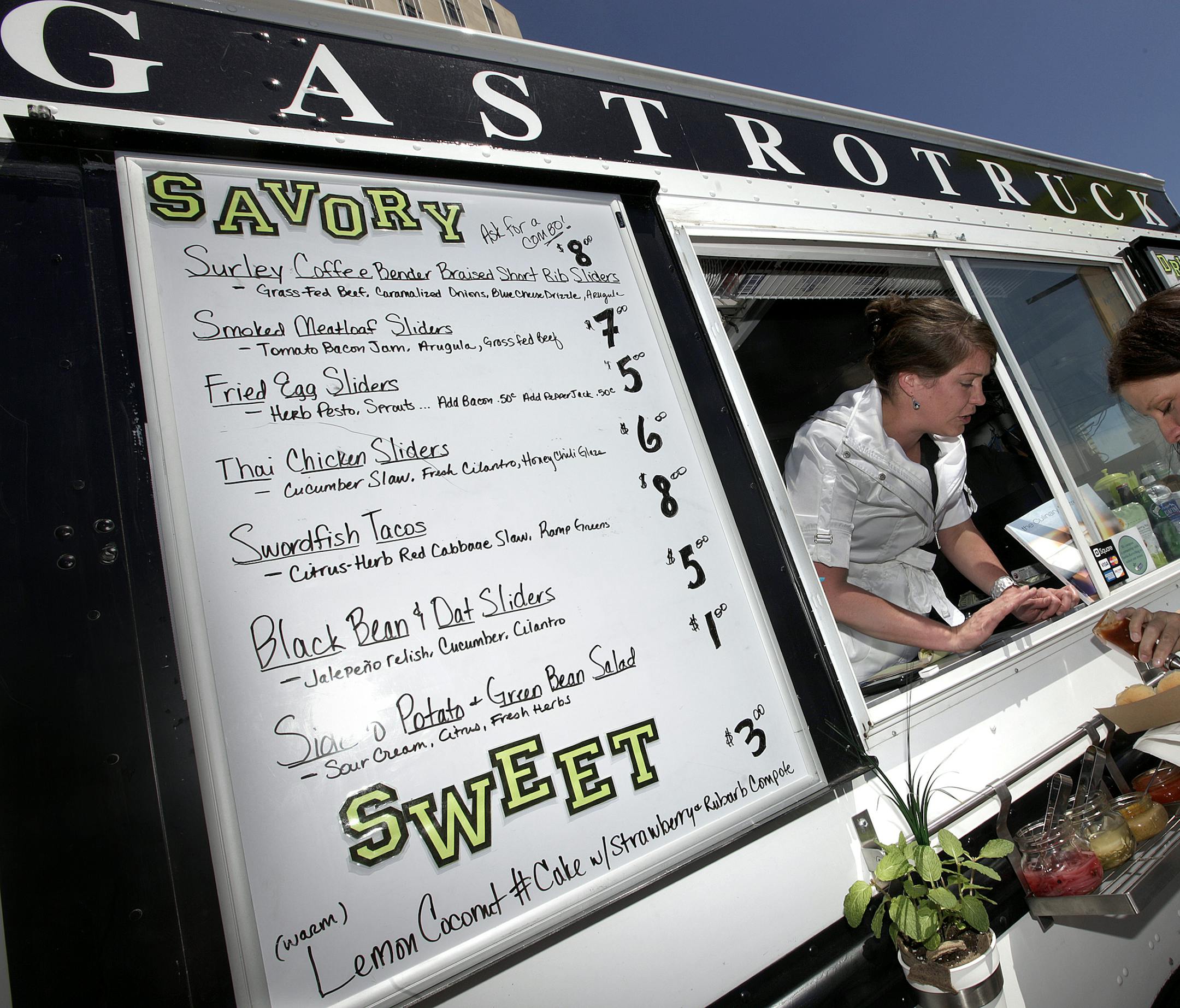 TOM WALLACE ¬• twallace@startribune.com Assignments #20017920A_ May 18, 2011_ SLUG: foodtrux.vita3_ Opening day of truck food court along Kellogg in St. Paul, MN _ IN THIS PHOTO:] The Gastrotruck, Cathrine Eckers passes food to customer Crystal Seelhammer. ORG XMIT: MIN2013062509152213