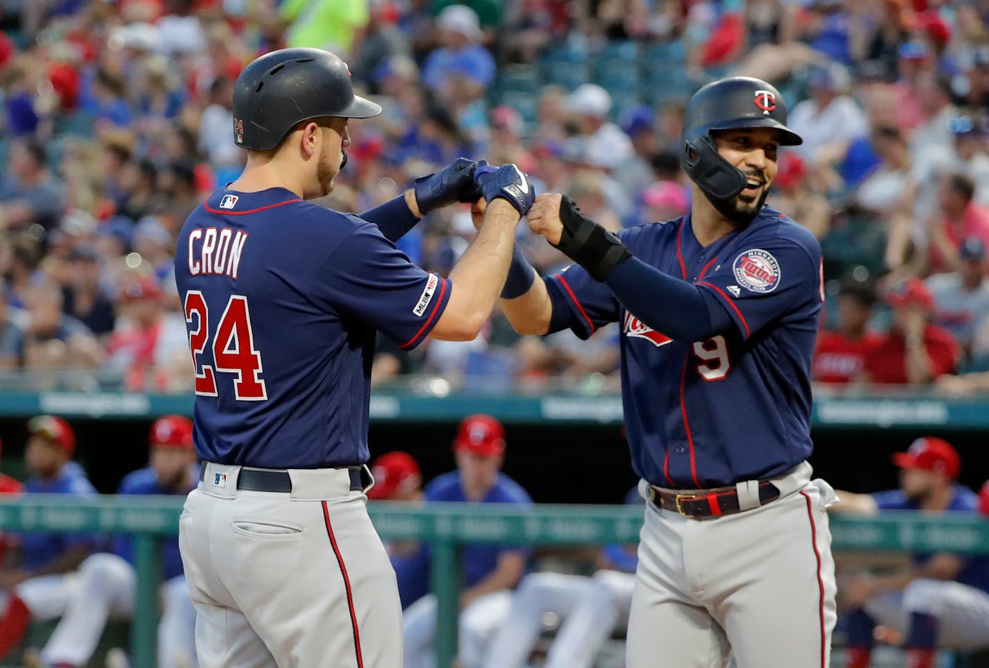 Minnesota Twins' C.J. Cron (24) and Marwin Gonzalez (9) celebrate Chron's two-run home run that scored Gonzalez in the first inning of a baseball game against the Texas Rangers in Arlington, Texas, Saturday, Aug. 17, 2019. (AP Photo/Tony Gutierrez)