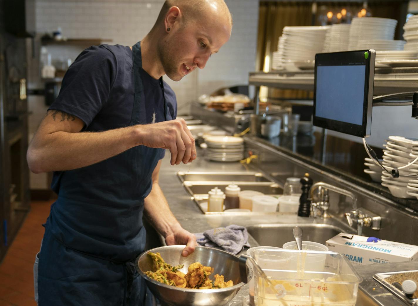 Fig and Farro general manager Joshua Hockstatter sprinkled a'tar spices on a bowl of the "Forgotten Foods" special made of deep fried tempura-battered vegetable scraps in Minneapolis, Minn., on Thursday, January 31, 2019. ] RENEE JONES SCHNEIDER &#xa5; renee.jones@startribune.com