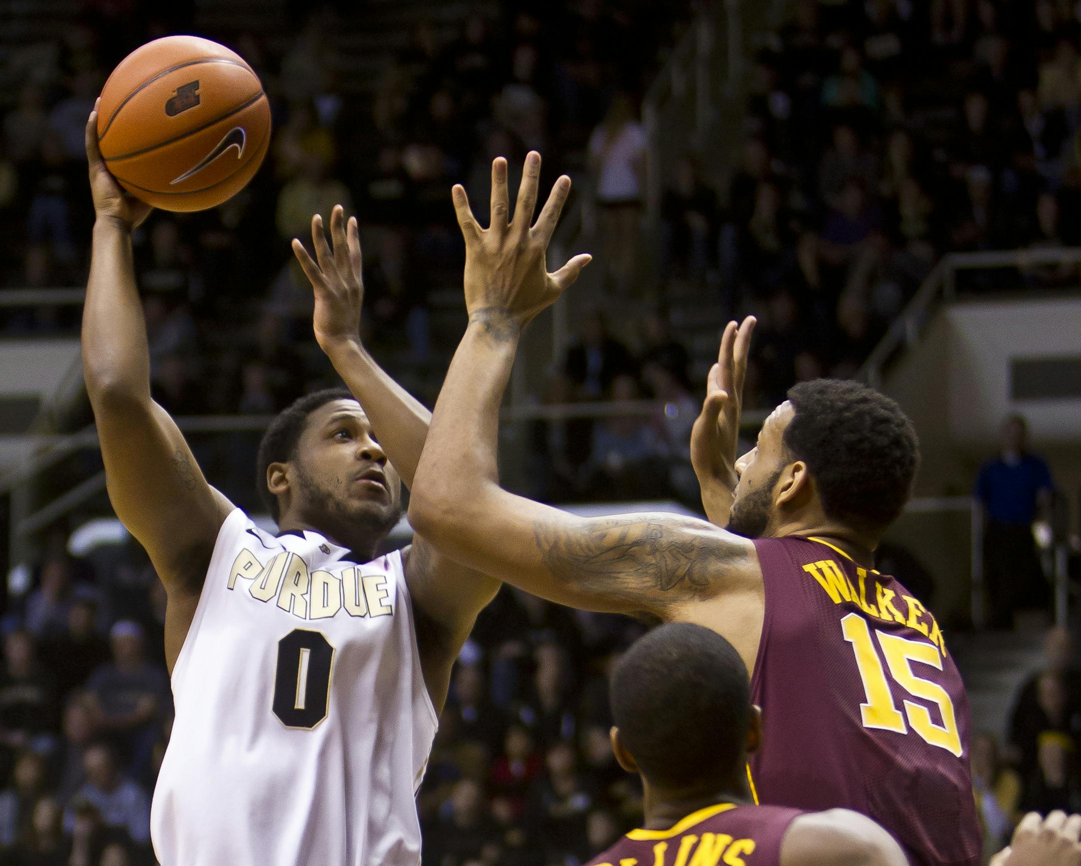 Purdue's Terone Johnson, left, takes a shot over Minnesota's Maurice Walker during an NCAA college basketball game Wednesday, Feb. 5, 2014, at Mackey Arena in West Lafayette, Ind. (AP Photo/Journal & Courier, Michael Heinz) NO SALES