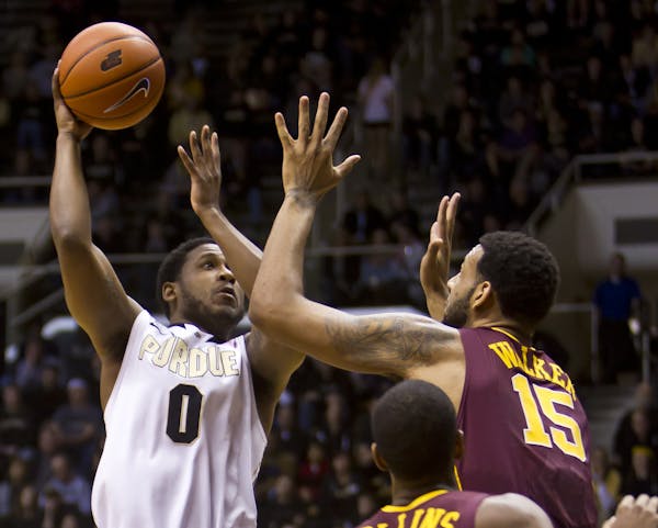 Purdue's Terone Johnson, left, takes a shot over Minnesota's Maurice Walker during an NCAA college basketball game Wednesday, Feb. 5, 2014, at Mackey 
