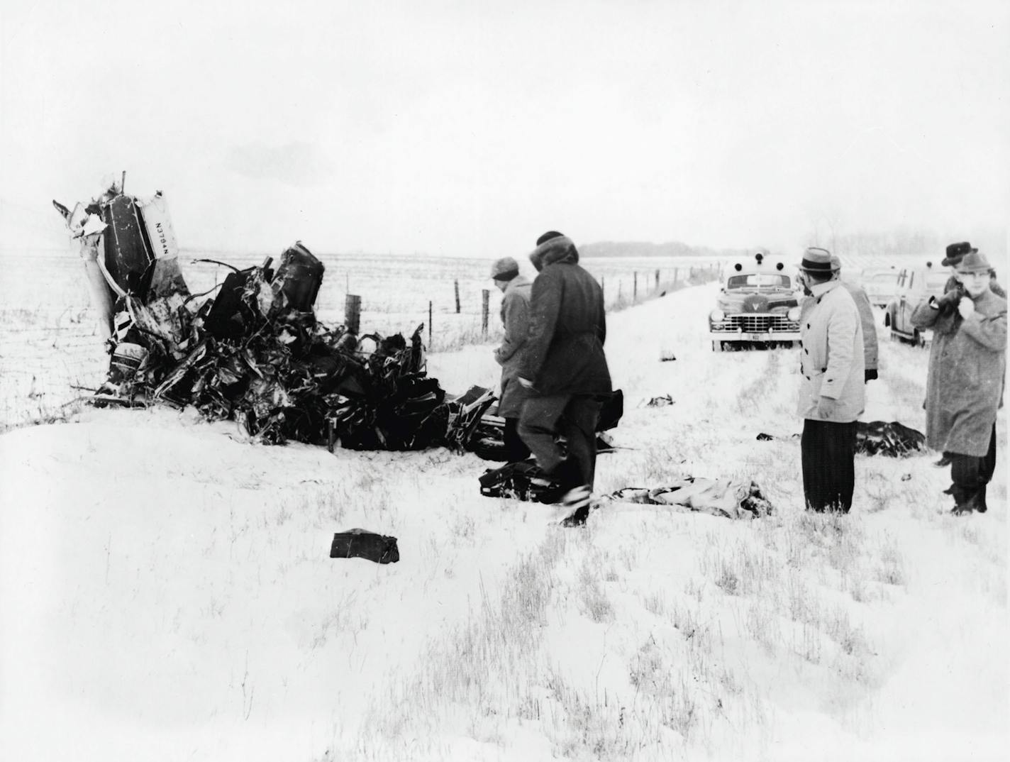 A group of men view of the wreckage of a Beechcraft Bonanza airplane in a snowy field outside of Clear Lake, Iowa, early February 1959. The crash, on Feb. 3, claimed the lives of American rock and roll musicians Buddy Holly, Ritchie Valens, and J. P. "The Big Bopper" Richardson.