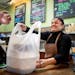 Sandra Mejia handed a takeout order to a customer at Vitali&#x2019;s Bistro in St. Louis Park. The restaurant uses biodegradable plastic bags but coul