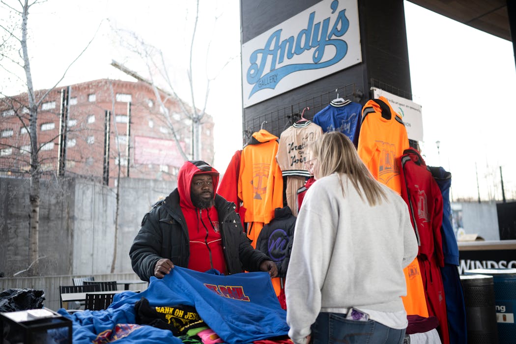 “Joe Peezy Wear” owner Joseph Paul shows one of his sweatshirts to a prospective customer at Andy’s Gallery in CHS Field. 