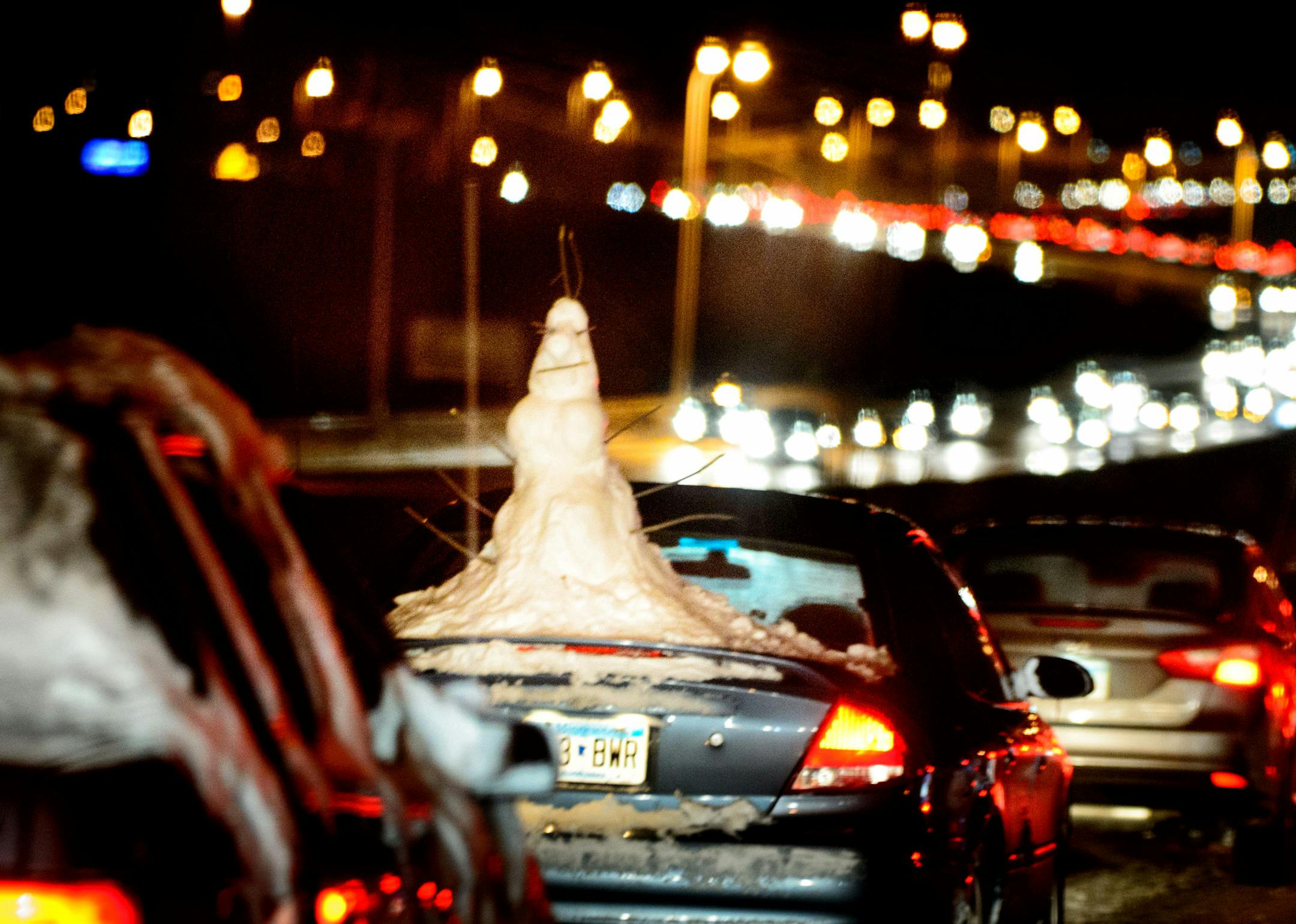 At least one driver maintained their sense of humor with a snowman trunk ornament as traffic crept along the washboard of compressed snow and ice of Hwy 77 southbound Friday night across the Minnesota River. Friday, February 21, 2014 ] GLEN STUBBE * gstubbe@startribune.com ORG XMIT: MIN1402211952390005