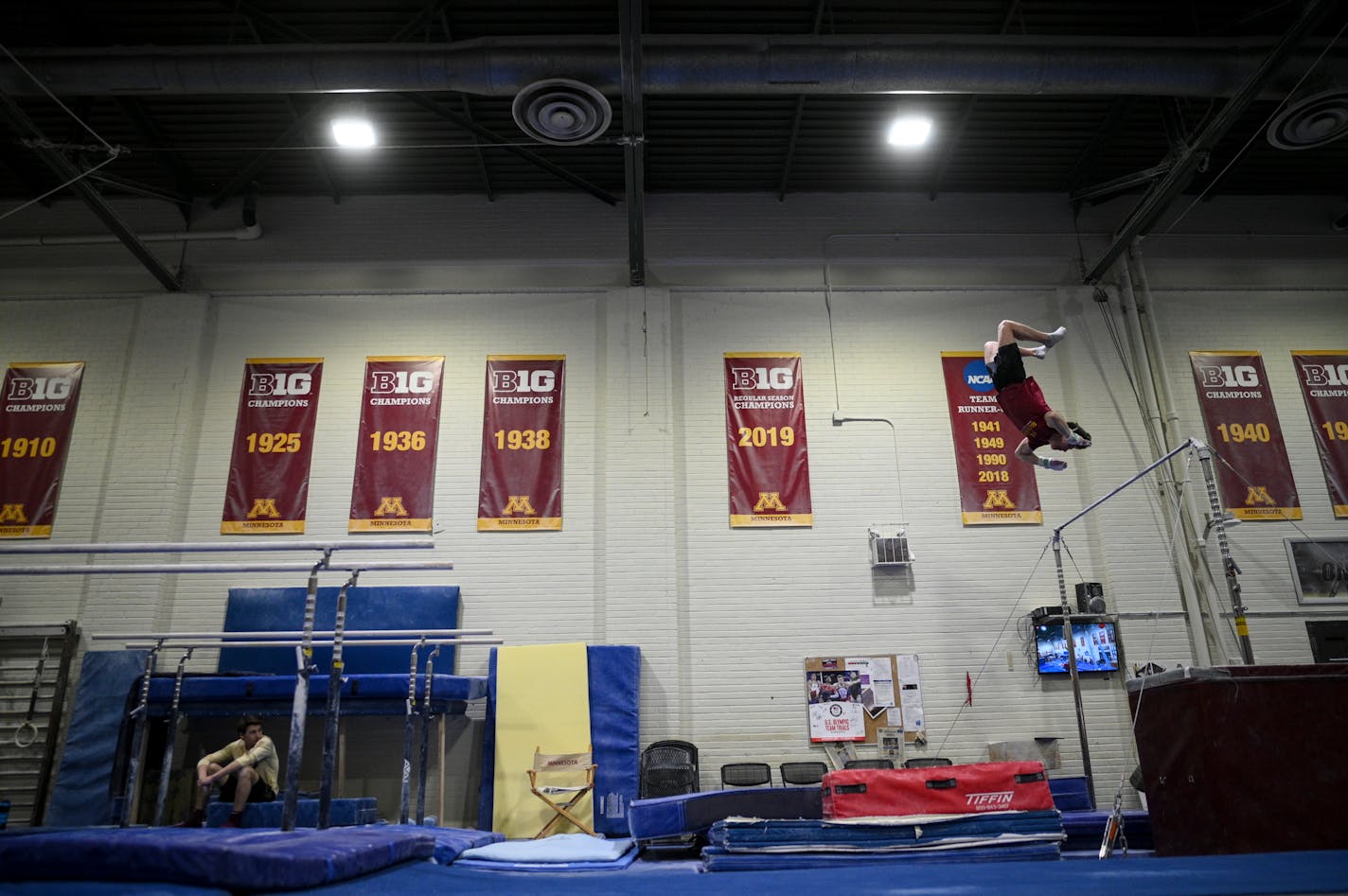 Gophers freshman Kellen Ryan dismounts from the high bar during practice Monday, April 25, 2022 at Cooke Hall in Minneapolis, Minn.. One season after the Gophers men's gymnastics team was cut, team members still compete for a club team in virtual meets, and the nationals start May 14. ] AARON LAVINSKY• Aaron.lavinsky@startribune.com