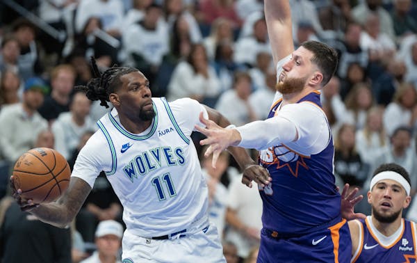 Wolves center Naz Reid passes the ball around Phoenix center Jusuf Nurkic during the fourth quarter Saturday at Target Center.