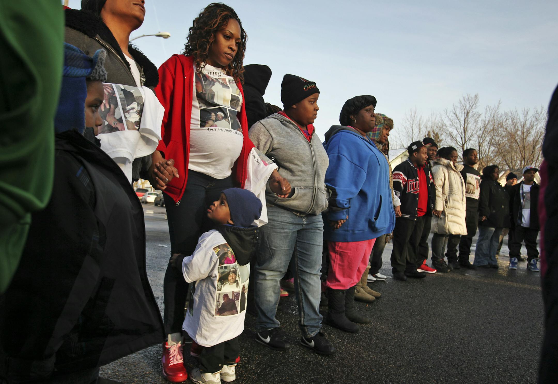 London Rozelle, in red, third from left, held hands with others during a vigil Thursday, March 14, 2013 for shooting victims Erick Felton and her boyfriend Demetrius Harper outside the illegal club on the northside where the men were shot and killed. Rozelle and Harper's other child Demetrius Harper III stood below his mother, who is nine months pregnant with Harper's child.] (DAVID JOLES/STARTRIBUNE) djoles@startribune.com A vigil is scheduled Thursday for the victims of last week's shooting at