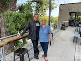 Sean Sherman and Lidia Bastianich at Owamni on the patio during the filming of Changemakers. Both are smiling to the camera.