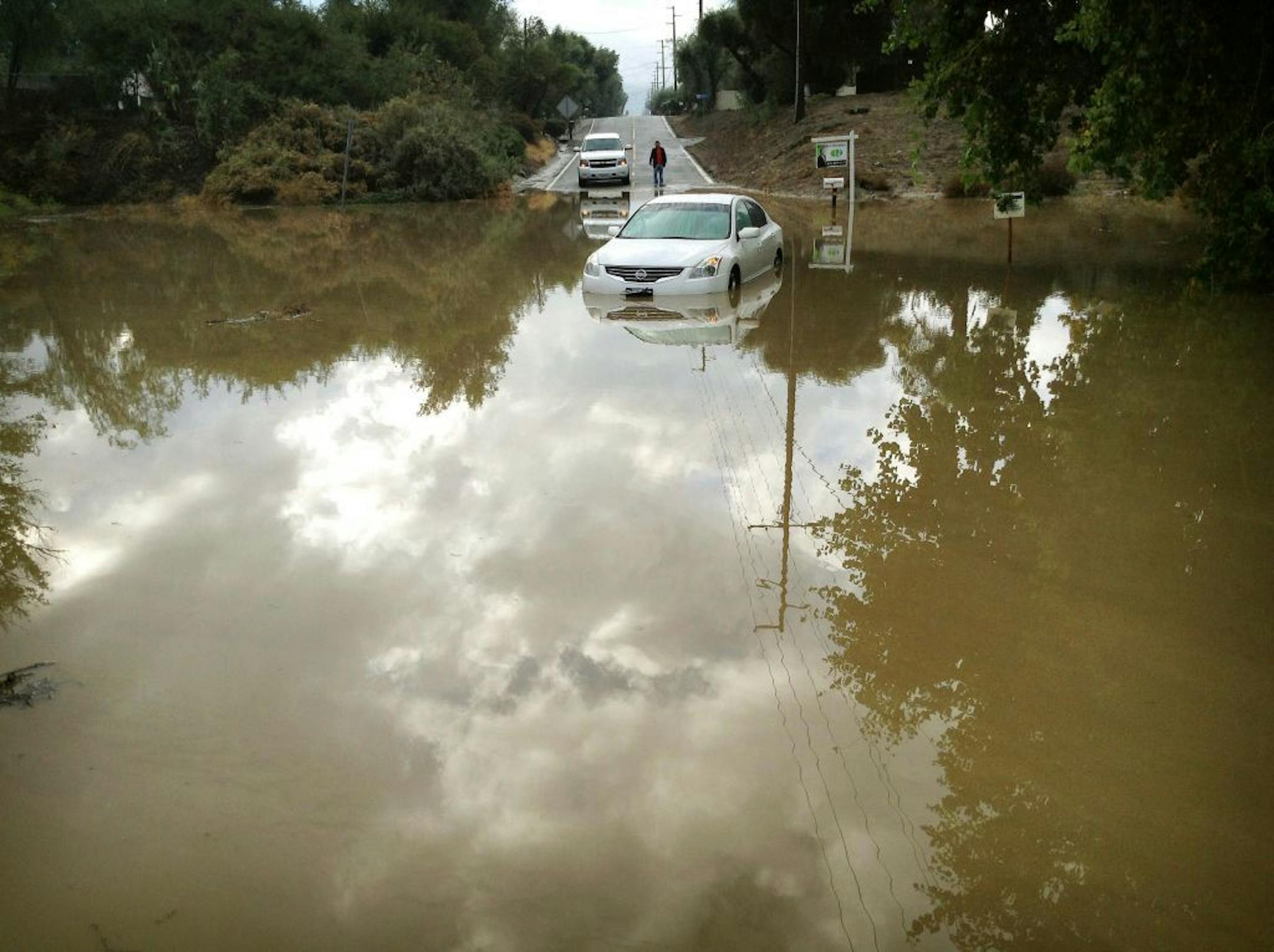 A car sits partially submerged in flood waters on Hemet Street in Hemet, Calif., Thursday morning, Dec. 4, 2014, after overnight rains doused the area. A second day of much-needed rain is falling across drought-stricken California. (AP Photo/The Press-Enterprise, Craig Shultz ) MAGS OUT; MANDATORY CREDIT ; LA TIMES OUT