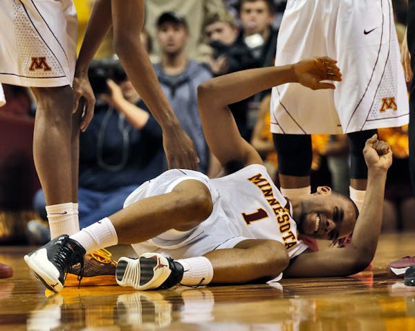 Minnesota guard Andre Hollins (1) went to the floor with an ankle injury in the opening moments of the game against Wisconsin.