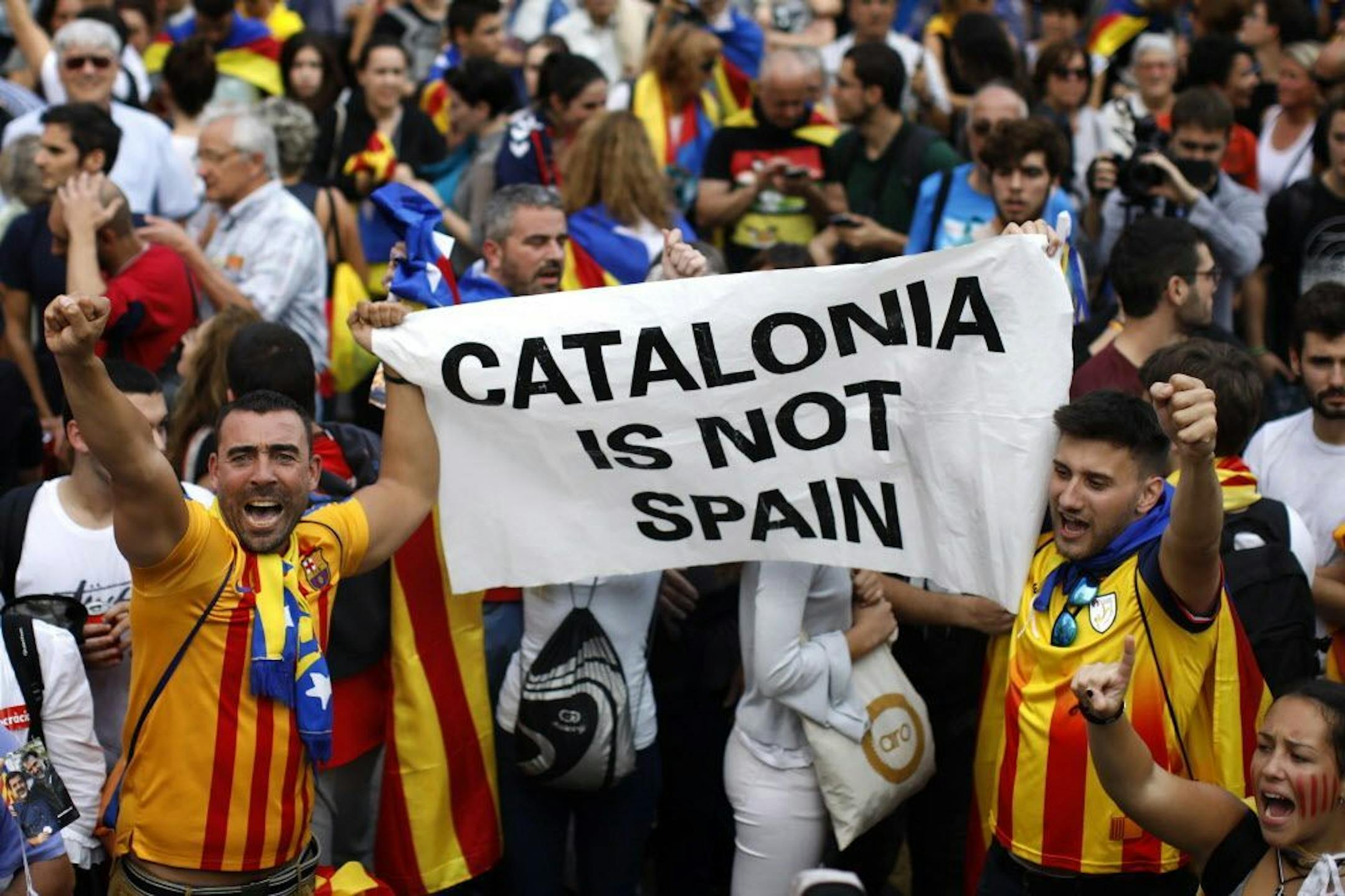 People react as they celebrate the unilateral declaration of independence of Catalonia outside the Catalan Parliament, in Barcelona, Spain, Friday, Oct. 27, 2017. Catalonias' regional Parliament passed a motion Friday to establish an independent Catalan Republic.
