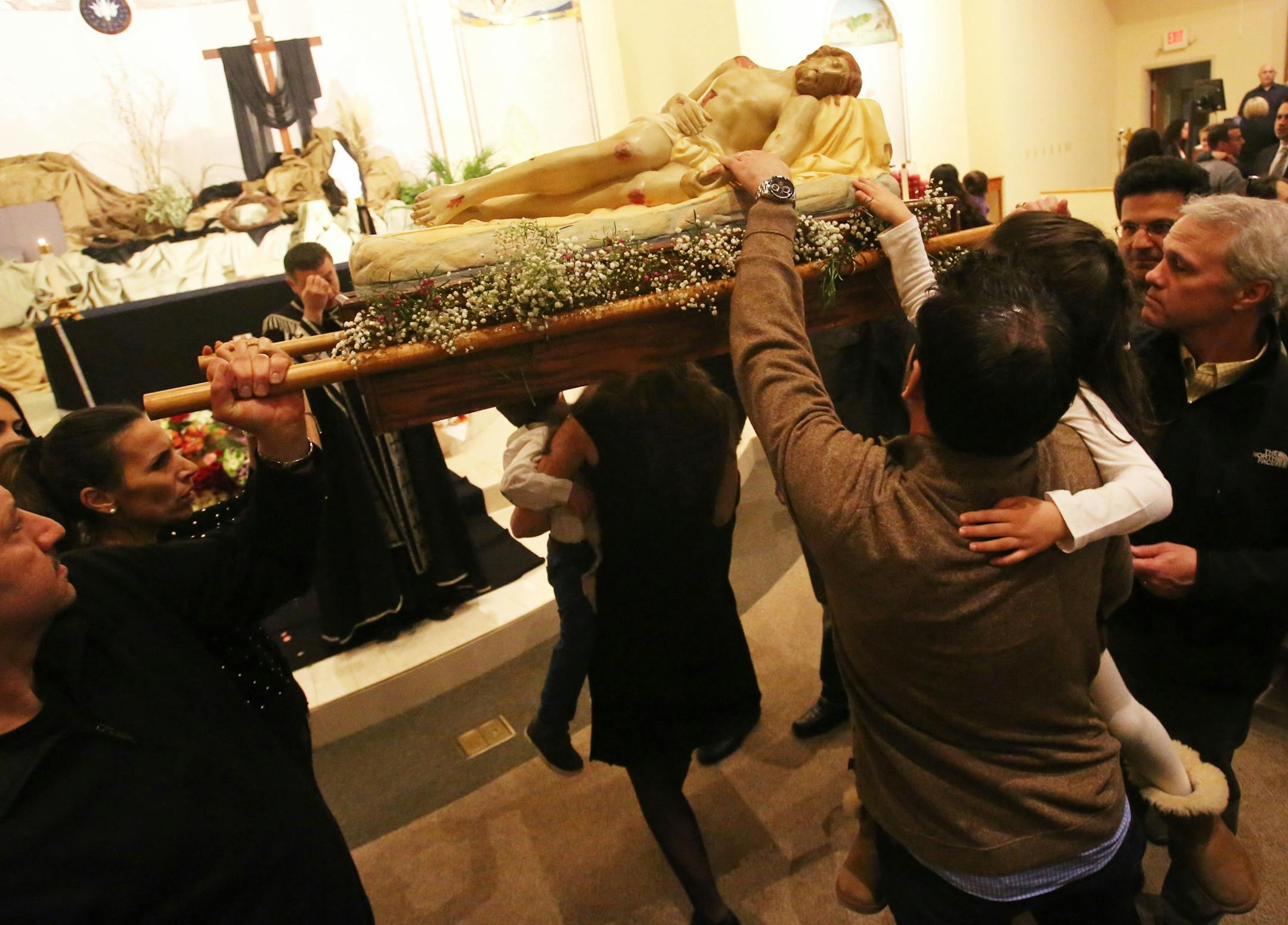 Worshipers touch the shroud of Jesus before passing beneath it during a Good Friday service Friday, March 26, 2016, at St. Maron's Catholic Church in Minneapolis.