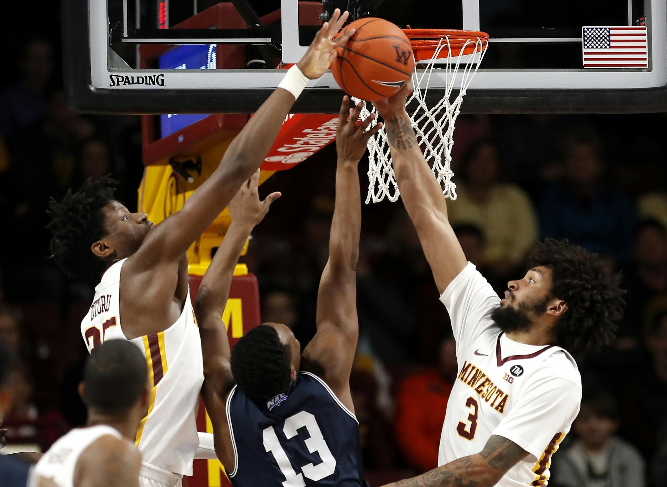 Minnesota center Daniel Oturu (25), left, and Minnesota forward Jordan Murphy (3) block a shot by Mount St. Mary's forward Omar Habwe (13) during the first half.