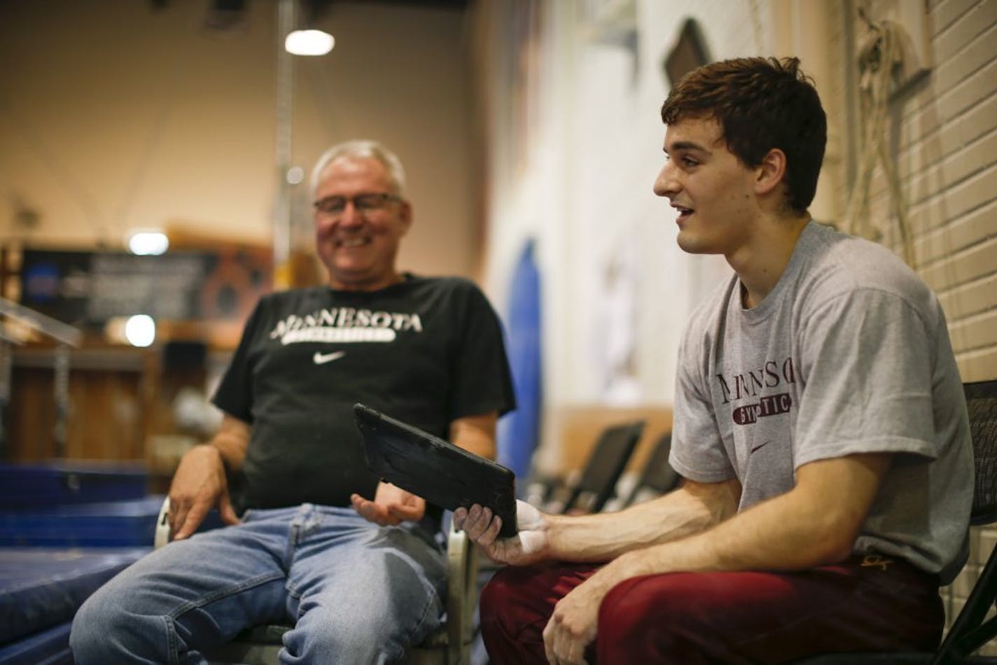 Gymnast Ellis Mannon handed an iPad to one of his coaches, Russ Fystrom, after reviewing video of his routine on the pommel horse during his workout in the Cooke Hall gymnastics room Tuesday night.