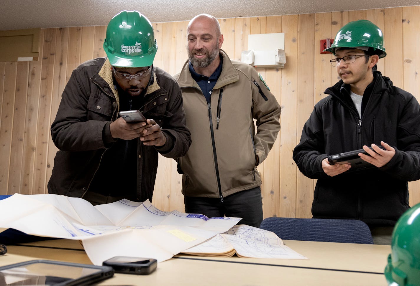 Minnesota Energy Climate Corps team member DeAndre Colquitte takes a photo of a building blueprint before resketching it during an energy audit Thursday, November 9, 2023, at Fort Snelling State Park in St. Paul, Minn. Also photographed are Conservationist supervisor Travis McCleary (middle) and Team leader Benjamin Ibarra. ] CARLOS GONZALEZ • carlos.gonzalez@startribune.com