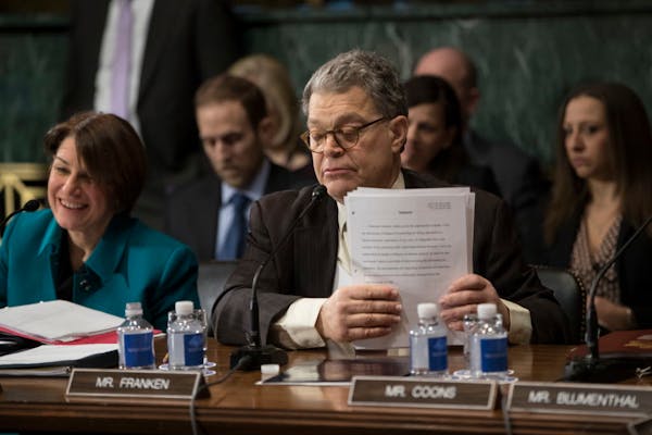 Sen. Al Franken, with Sen. Amy Klobuchar to his left, concludes his remarks on Capitol Hill during the confirmation hearing for Attorney General Jeff 